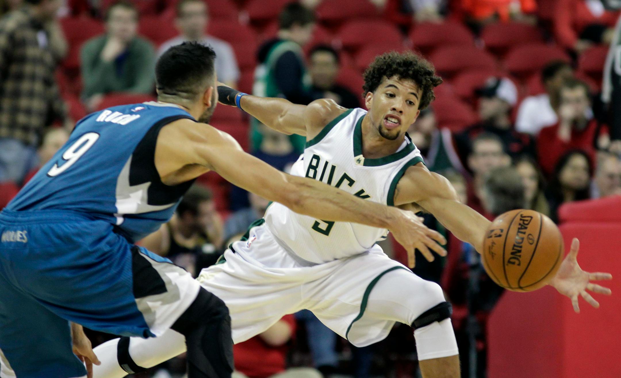 Milwaukee Bucks' Michael Carter-Williams, right, reaches in on a pass by Minnesota Timberwolves' Ricky Rubio during the first half of an NBA preseason basketball game Tuesday, Oct. 20, 2015, in Madison, Wis. (AP Photo/Andy Manis)