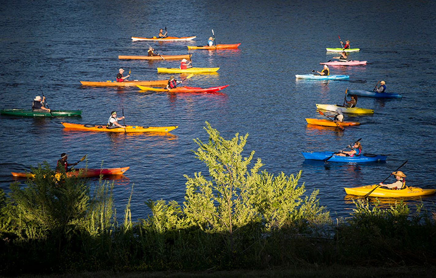 Two lines of kayaks crossed paths by paddling past each other during the during a rehearsal for the Mississippi River Boat Ballet on the Mississippi River in Minneapolis, Minn., on Wednesday, July 29, 2015.