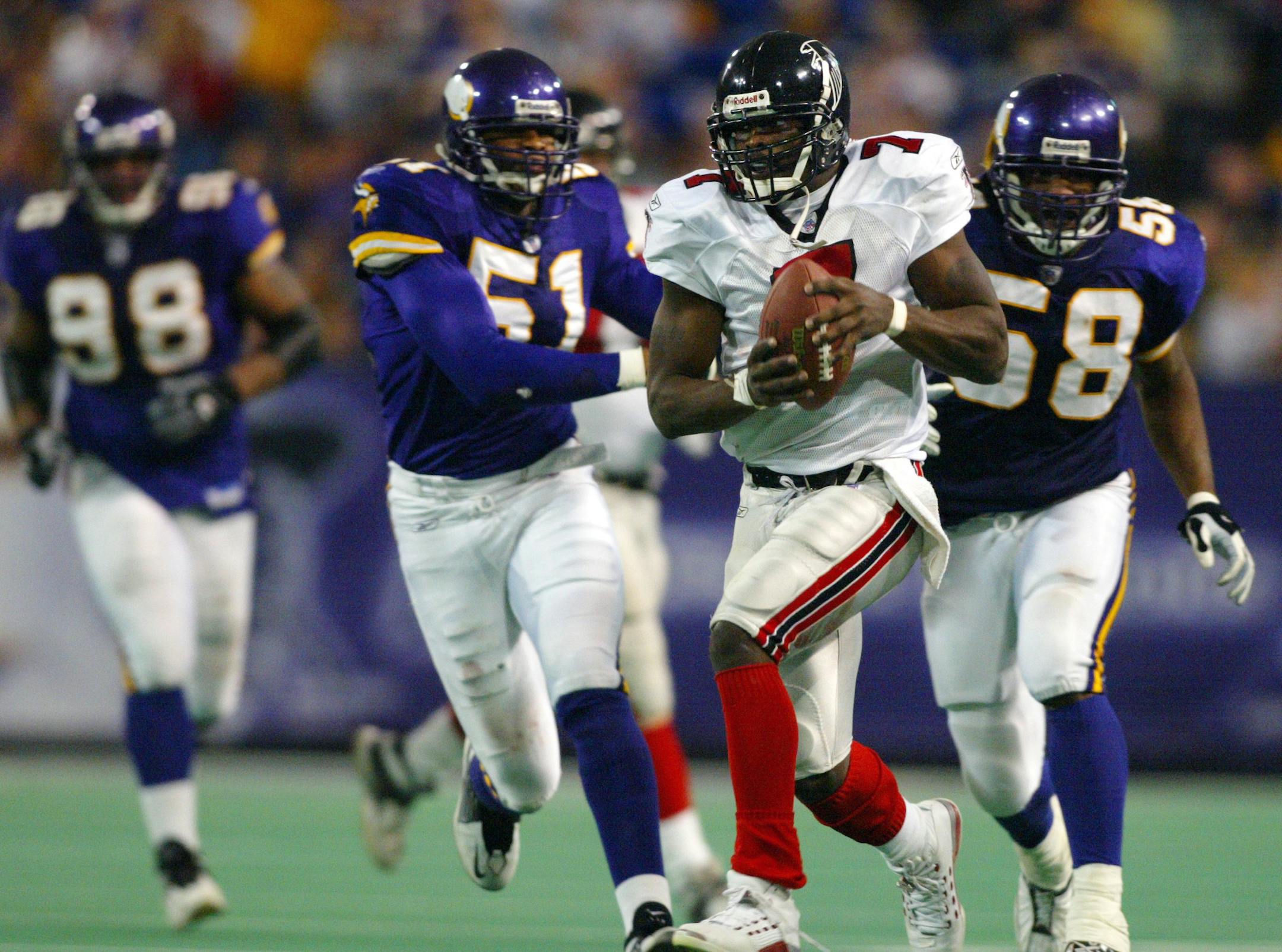 Minneapolis, MN 12/1/2002 Metrodome- Vikings-vs-Atlanta Atlanta QB superstar Michael Vick breaks away from the Vikings defense, #98 Fred Robbins #51 Lance Johnstone and #58 Nick rodgers for a 46 yard TD run to win the game in overtime 30 to 24.