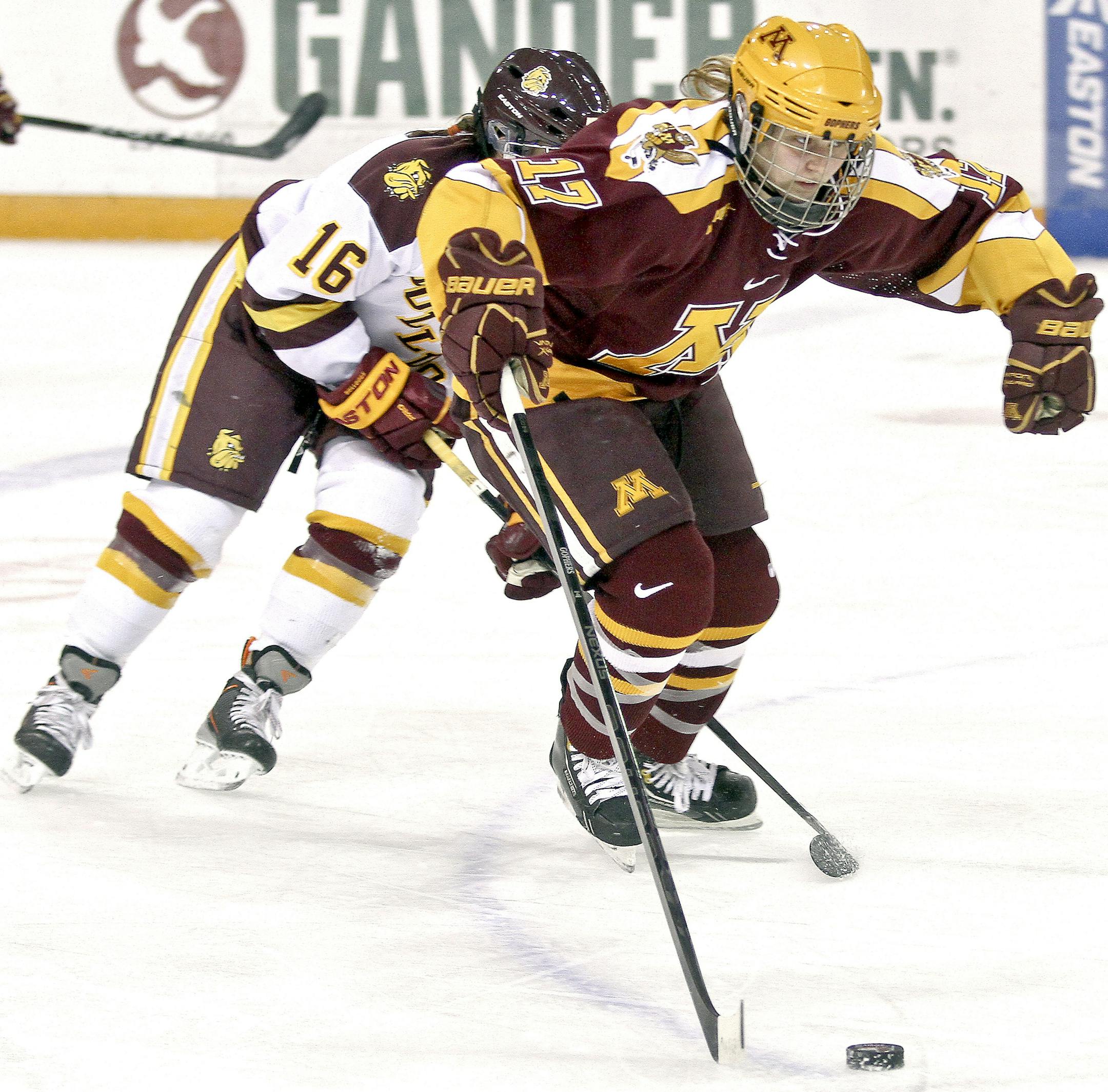 Minnesota Duluth left wing Jamie Kenyon (16) and Minnesota defensive player Jordyn Burns (17) compete for the puck during a hockey game Friday, Oct. 18, 2013 in Duluth, Minn. Minnesota shutout Minnesota Duluth 4-0. (AP Photo/The Duluth News-Tribune, Clint Austin)