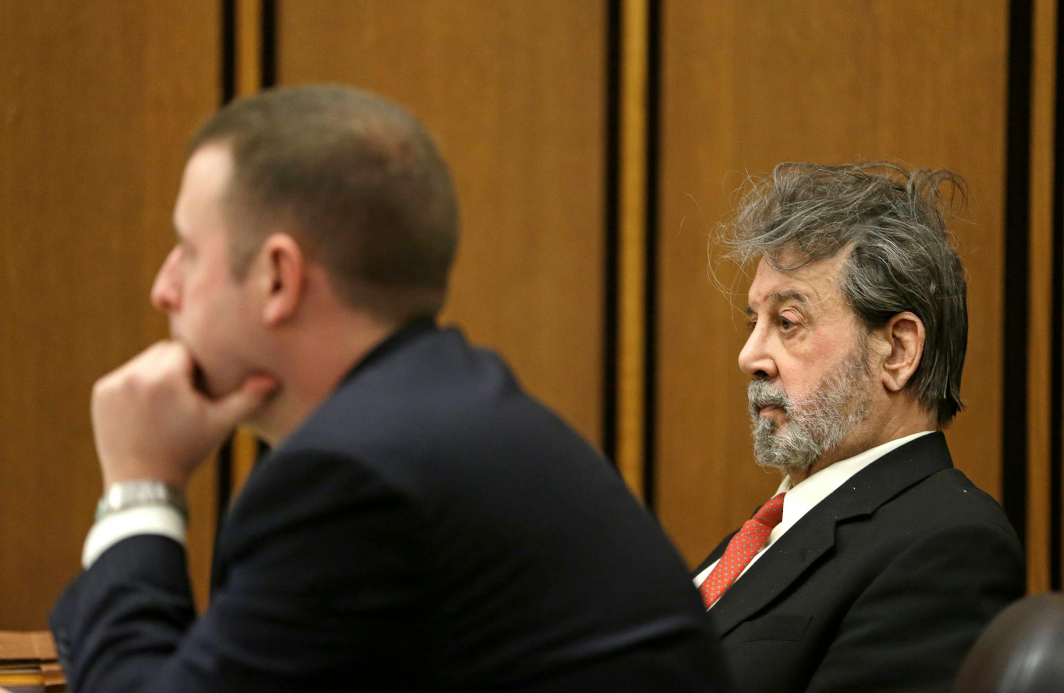 Defendant Bobby Thompson, right, who authorities say is a Harvard-trained attorney and former military intelligence officer named John Donald Cody, listens to testimony Tuesday, Nov. 5, 2013, in Cleveland. Thompson is charged with defrauding donors to a reputed charity, the United States Navy Veterans Association based in Tampa, Fla. Defense attorney Joseph Patituce, left, listens. (AP Photo/Tony Dejak)