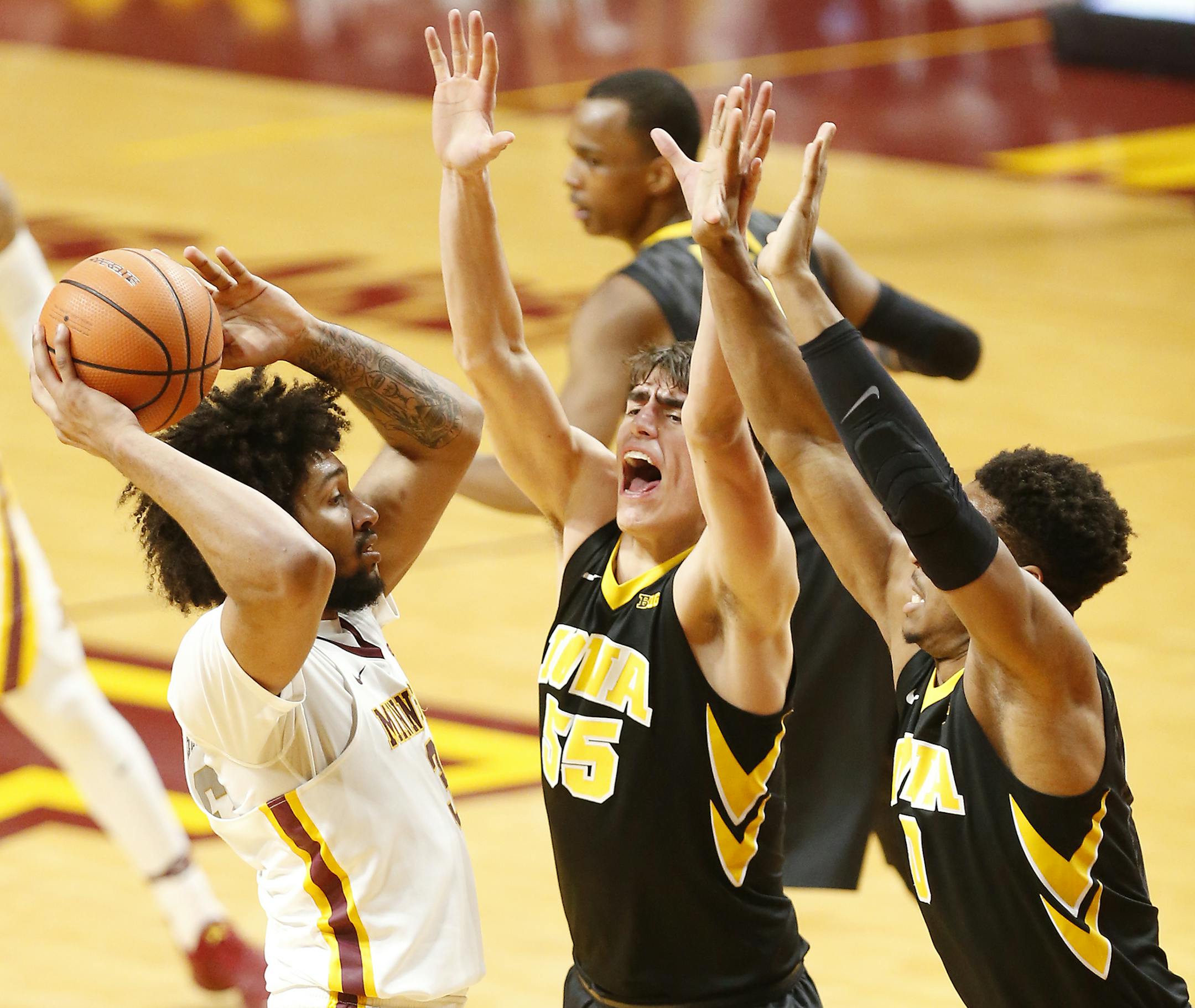Minnesota Golden Gophers forward Jordan Murphy (3) is guarded by Iowa Hawkeyes forward Luka Garza (55) amd Iowa Hawkeyes forward Ahmad Wagner (0) during the first half. ] LEILA NAVIDI ï leila.navidi@startribune.com BACKGROUND INFORMATION: The Minnesota Golden Gophers men's basketball team plays against the Iowa Hawkeyes at Williams Arena in Minneapolis on Wednesday, February, 21, 2018.