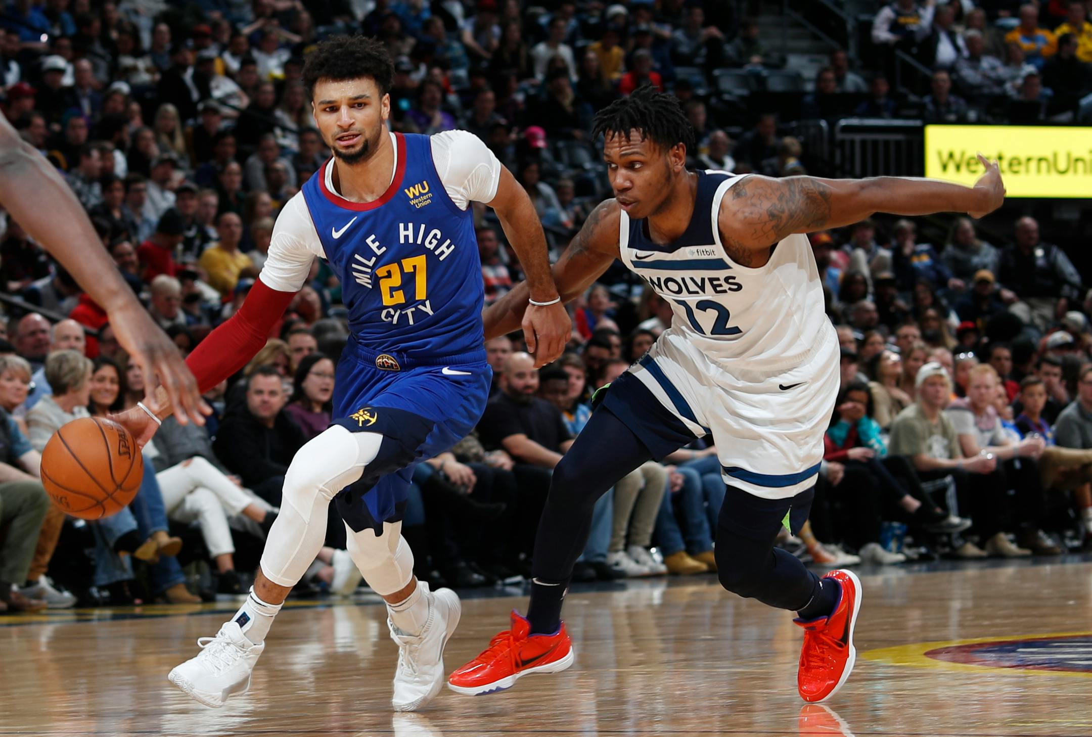Denver Nuggets guard Jamal Murray, left, drives past Minnesota Timberwolves guard Treveon Graham during the second half of an NBA basketball game Friday, Dec. 20, 2019, in Denver. The Nuggets won 109-100. (AP Photo/David Zalubowski)