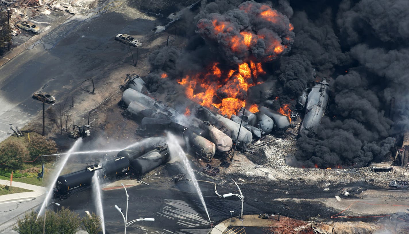 FILE - Smoke rises from railway cars that were carrying crude oil after derailing in downtown Lac Megantic, Quebec, Canada, Saturday, July 6, 2013.