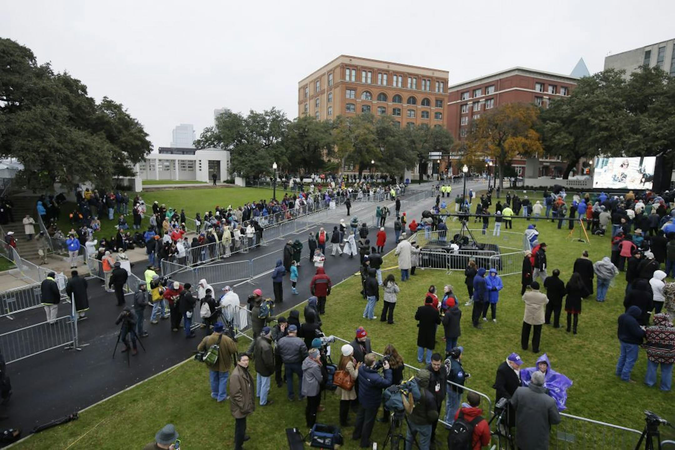 A crowd moves into position before a ceremony to mark the 50th anniversary of the assassination of John F. Kennedy, Friday, Nov. 22, 2013, at Dealey Plaza in Dallas.