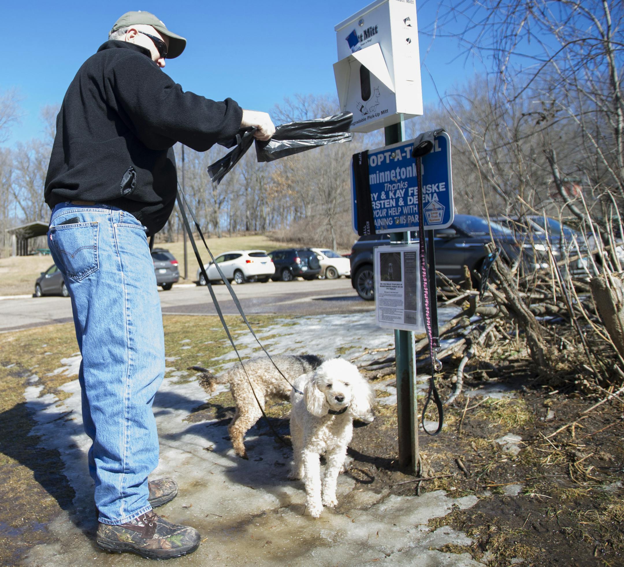 Rich Westling grabbed a "Mutt Mitt" before he walked his dogs Rusty and Copper at Purgatory Park in Minnetonka, Minn., on Tuesday, March 10, 2015. ] RENEE JONES SCHNEIDER • reneejones@startribune.com