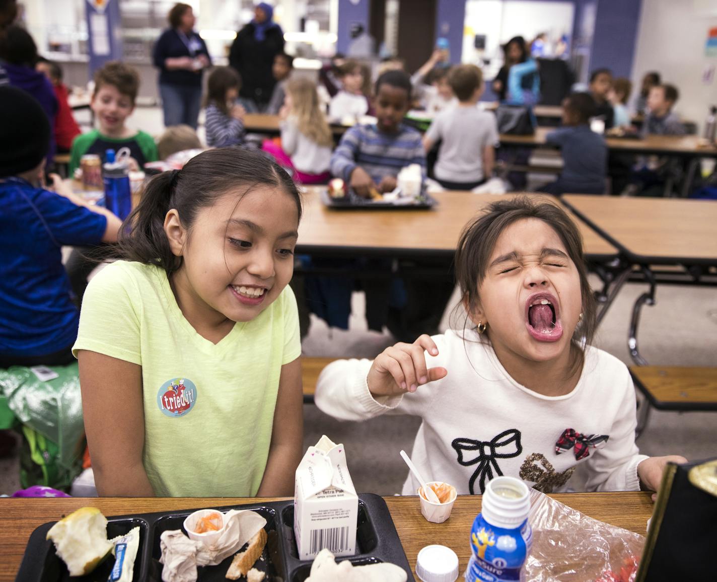 Second-graders Josselin San Martin Munguia, left, sat next to her friend Siclali Valles Mendoza as she reacted to the spice while eating kimchi. Valles Mendoza compared it to her mom's homemade ceviche, "But my mom doesn't make it that spicy," she said.