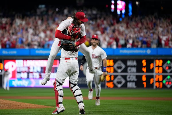 Philadelphia Phillies pitcher Michael Lorenzen, left, and J.T. Realmuto celebrate after Lorenzen's no-hitter during a baseball game against the Washin