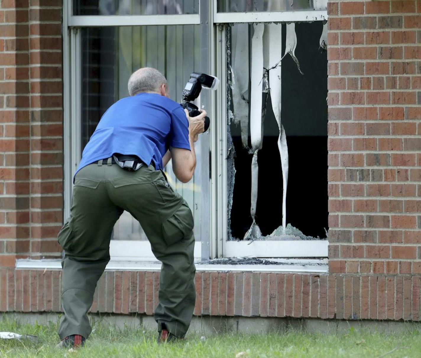 Law enforcement officials investigate an explosion at the Dar Al-Farooq Islamic Center in Bloomington, Minn., on Saturday, Aug. 5, 2017. Bloomington police Chief Jeff Potts said Saturday that investigators are trying to determine the cause of the blast. Authorities say the explosion damaged one room but it didn't hurt anyone.