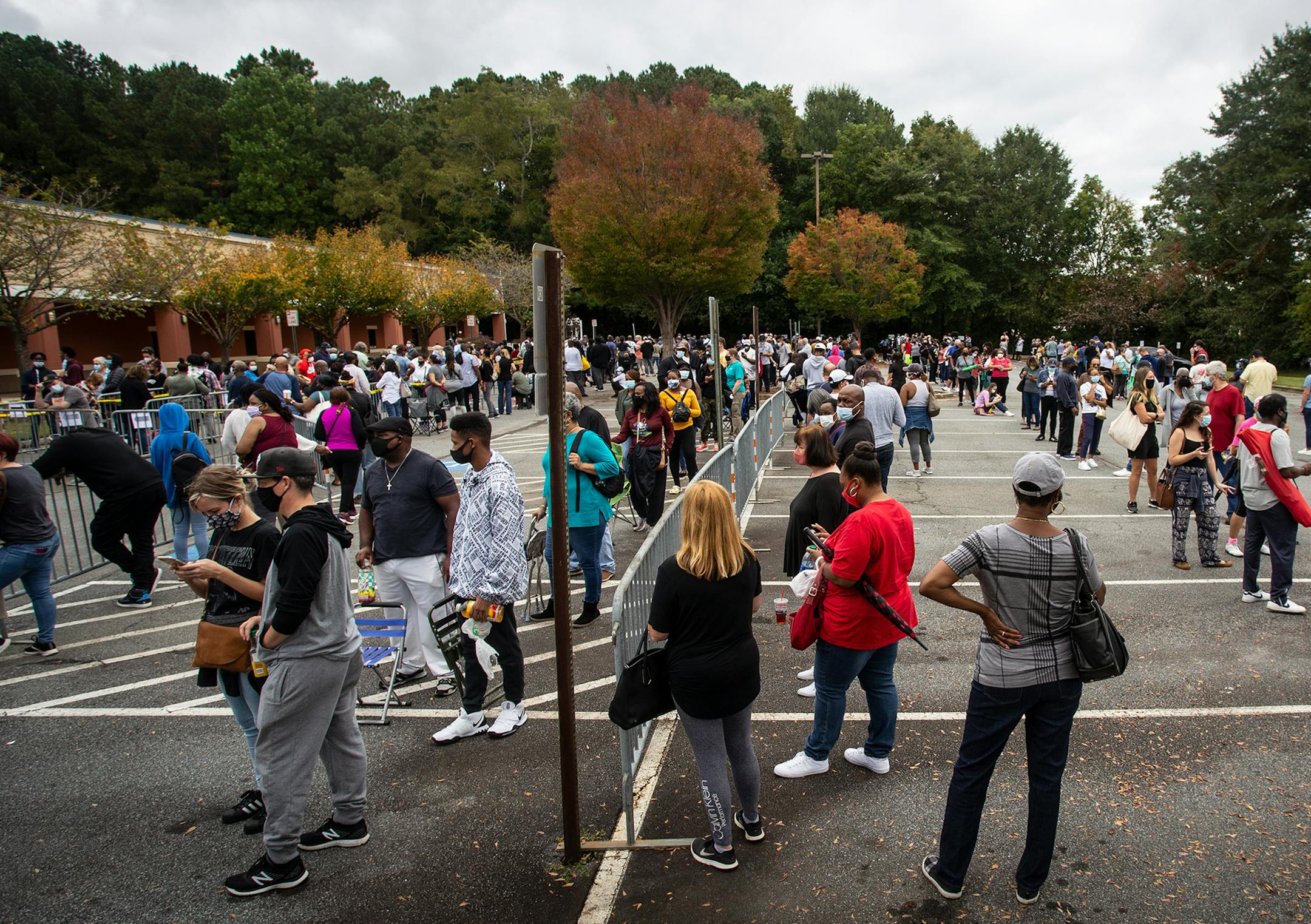 FILE - In this Oct. 12, 2020, file photo, hundreds of people wait in line for early voting in Marietta, Ga. Black people are going to the polls by the thousands and waiting in lines for hours to vote early in Georgia. Black people are going to the polls by the thousands and waiting in lines for hours to vote early in Georgia. (AP Photo/Ron Harris, File)