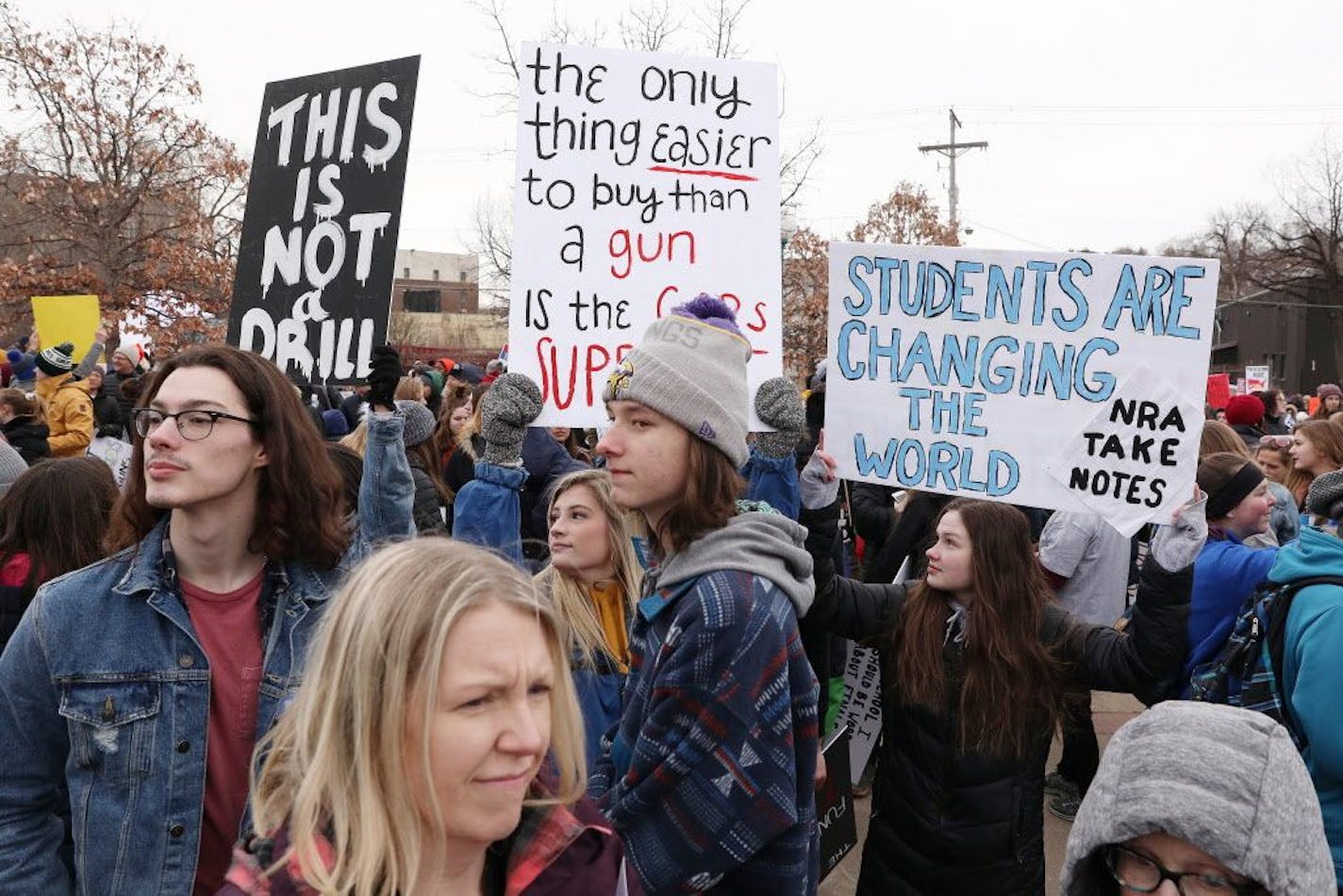 Students, including Grace Knutson, 18, of Woodbury, center, and Abbey Hennessy, 18, of Woodbury, right, gathered at Harriet Island Regional Park in St. Paul before matching to the State Capitol protesting gun violence Saturday.