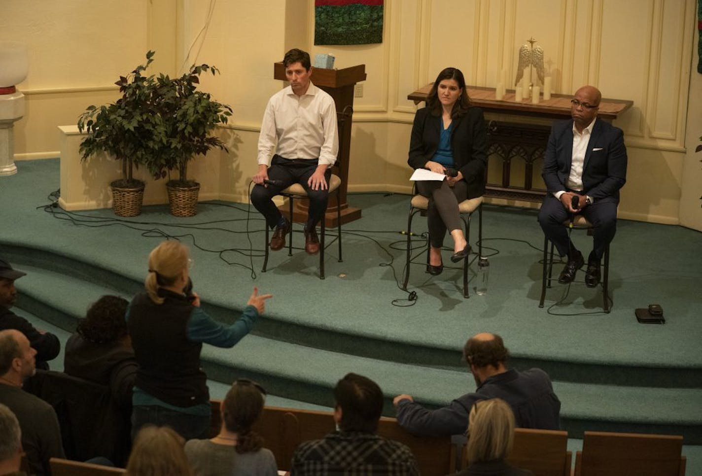 Minneapolis Mayor Jacob Frey, Council Member Linea Palmisano and Police Chief Medaria Arradondo, from left, listened Tuesday night as an audience member recounted an incident she witnessed where Minneapolis police drew their guns and confronted a teenager walking down her street.