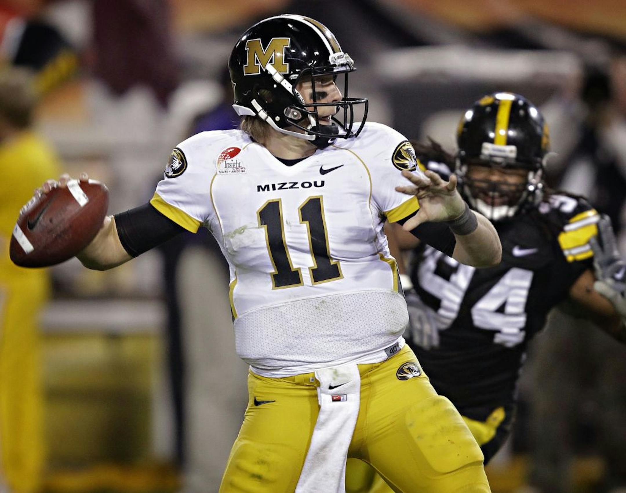 Missouri quarterback Blaine Gabbert (11) throws as Iowa Hawkeyes defensive end Adrian Clayborn (94) pursues during the third quarter of the Insight Bowl NCAA college football game Tuesday, Dec. 28, 2010, in Tempe, Ariz.