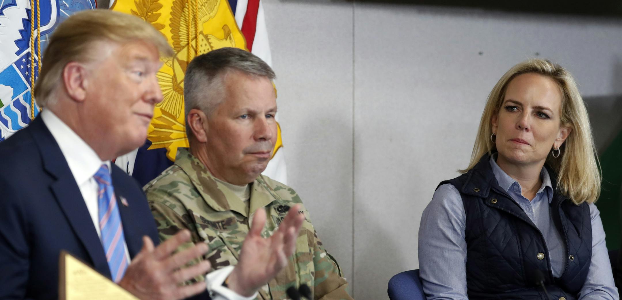 Lt. Gen. Todd Semonite, commanding General of the U.S. Army corps of Engineers , center and Homeland Security Secretary Kirstjen Nielsen, listens as President Donald Trump participates in a roundtable on immigration and border security at the U.S. Border Patrol Calexico Station in Calexico, Calif., Friday April 5, 2019. Trump headed to the border with Mexico to make a renewed push for border security as a central campaign issue for his 2020 re-election. (AP Photo/Jacquelyn Martin)