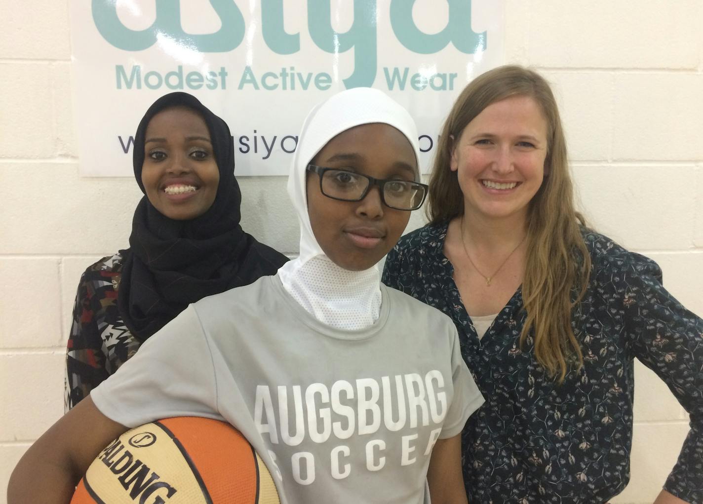 Asiya co-founders Fatimah Hussein (left) and Jamie Glover (right) flank Nabiiha Farah, a "Girls Win" club member who models a lightweight "Asiya Sport" hijab for female Muslim athletes. Neal.St.Anthony@startribune.com