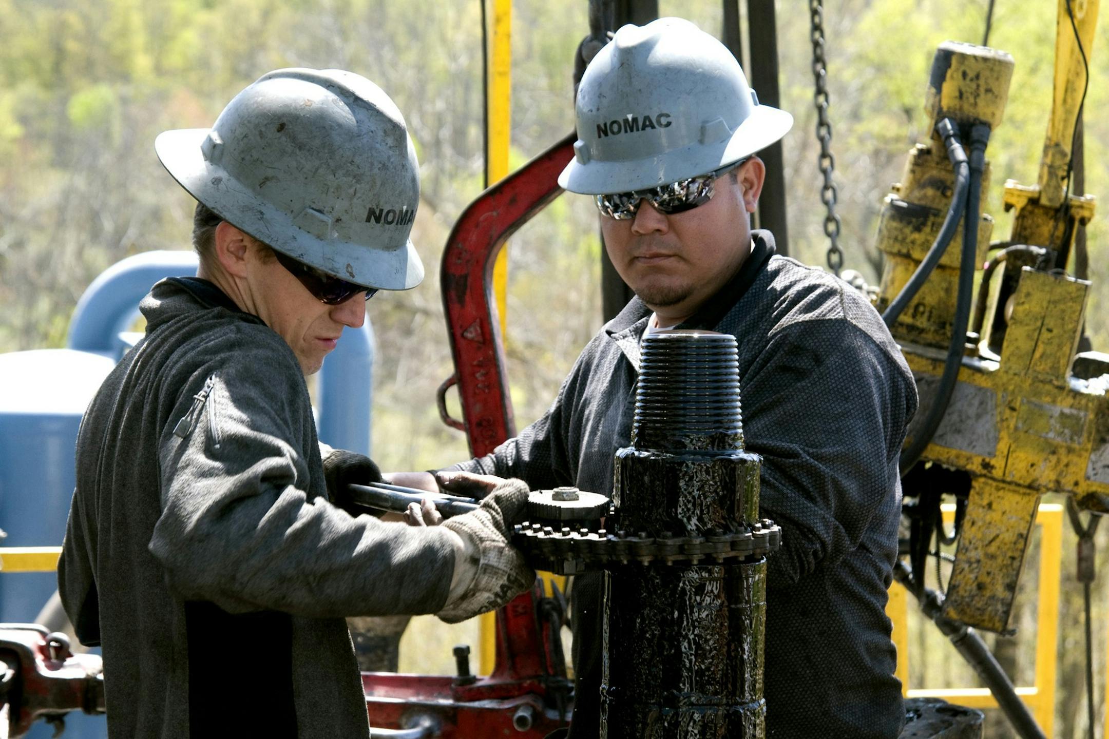 In this April 23, 2010 photo, workers move a section of well casing into place at a Chesapeake Energy natural gas well site near Burlington, Pa., in Bradford County. So vast is the wealth of natural gas locked into dense rock deep beneath Pennsylvania, New York, West Virginia and Ohio that some geologists estimate it's enough to supply the entire East Coast for 50 years. But freeing it requires a powerful drilling process called hydraulic fracturing or "fracking,"using millions of gallons of wat