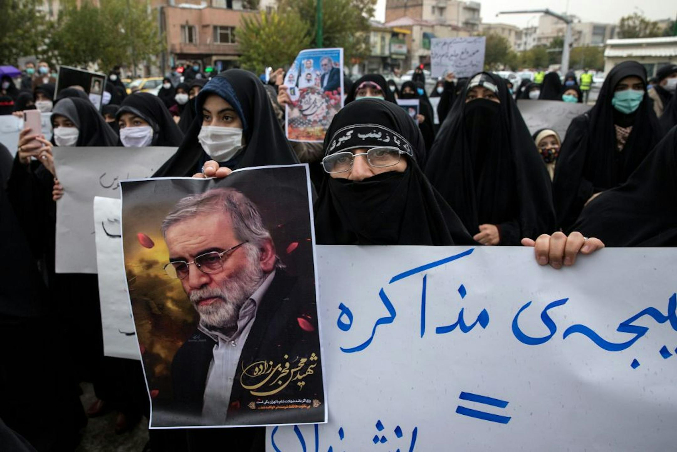 A protester holds an image of the Iranian nuclear scientist Mohsen Fakhrizadeh during a demonstration in Tehran on Saturday, Nov. 28, 2020, a day after Fakhrizadeh was killed. After suffering a string of audacious attacks, Tehran faces an agonizing choice: embracing hard-liner demands for swift retaliation or trying to make a fresh start with the Biden administration.