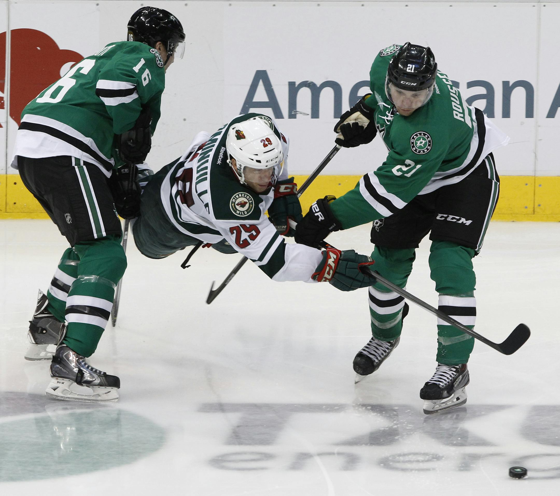 Dallas Stars left wing Ryan Garbutt (16) and Antoine Roussel (21) vie with Minnesota Wild right wing Jason Pominville (29) for the puck in the third period during an NHL hockey game in Dallas on Saturday, March 8, 2014. The Stars won 4-3. (AP Photo/ Richard W. Rodriguez)