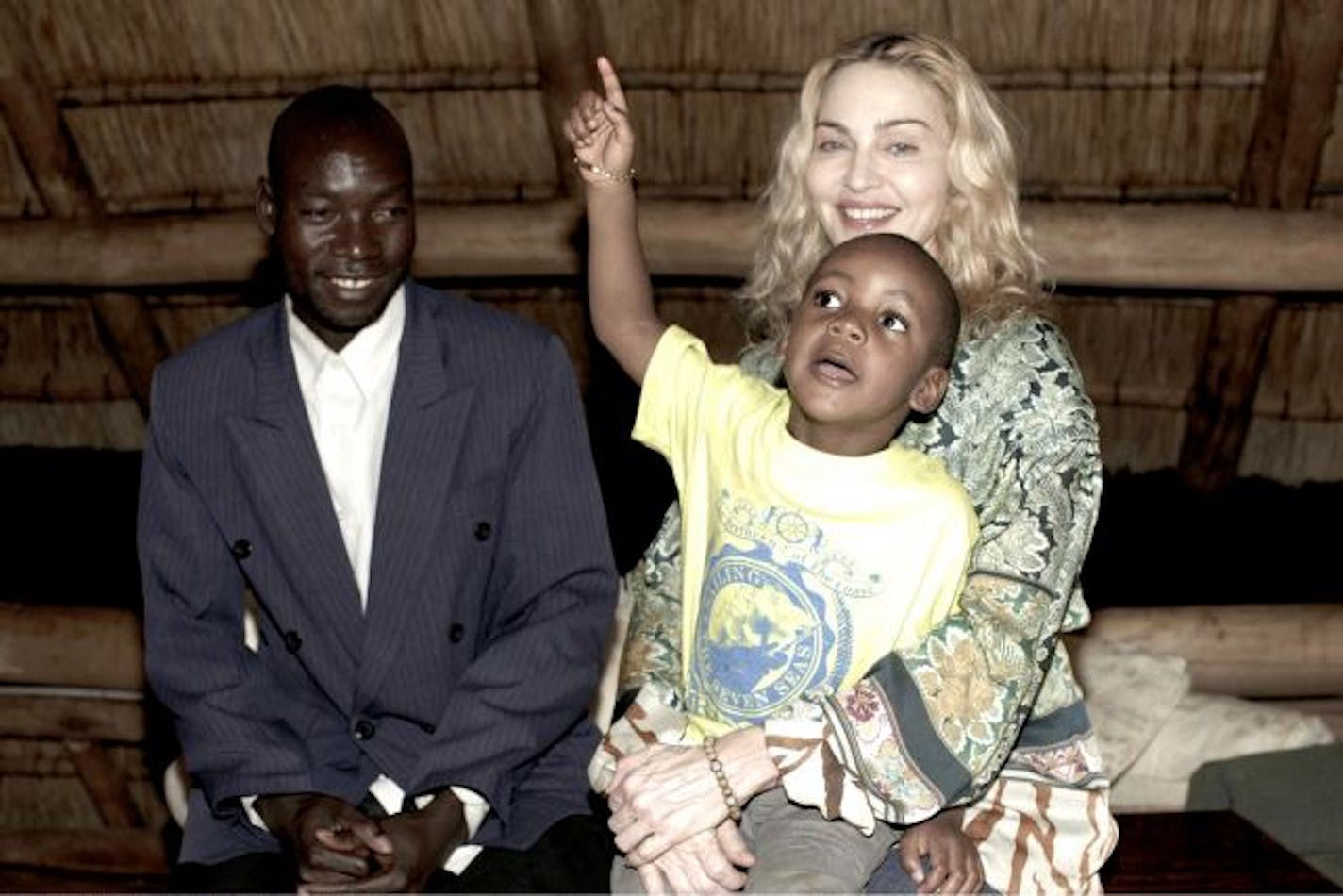 Madonna holds her adopted son David as they meet with the boy's biological father, Yohane Banda, left, at a lodge where the pop star is staying in Malawi, Monday March 30, 2009.