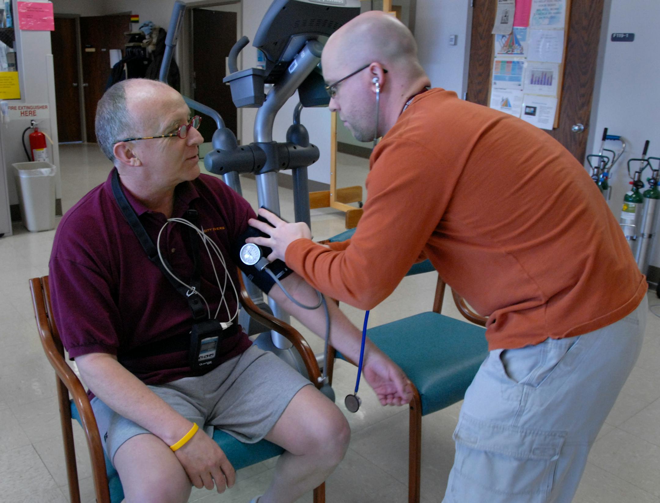 (Left to right) John Dailey had his blood pressure checked by cardiac rehabilitation therapist Kyle Erickson after a monitored exercise class at University of Minnesota Medical Center, Fairview. Three weeks ago Dailey had a heart attack.