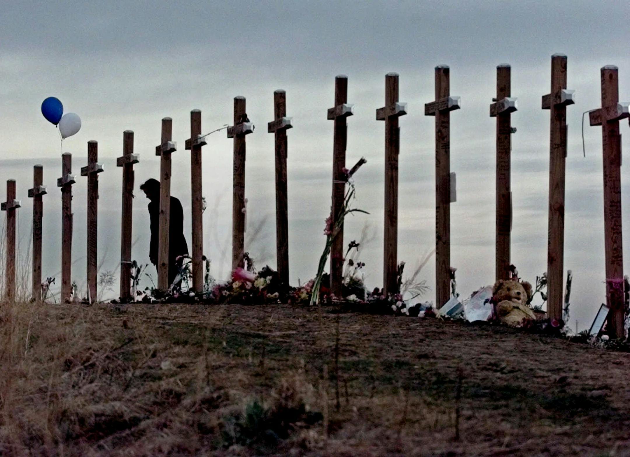 FILE - In this April 28, 1999, file photo, a woman stands among 15 crosses posted on a hill above Columbine High School in Littleton, Colo., in remembrance of the 15 people who died during a school shooting on April 20, 1999. The mother of Columbine High School shooter Dylan Klebold said she didn't know anything was wrong with her son before the 1999 attack, and she prayed for his death when she heard he was involved and that the rampage might still be underway. In an interview that aired on "20
