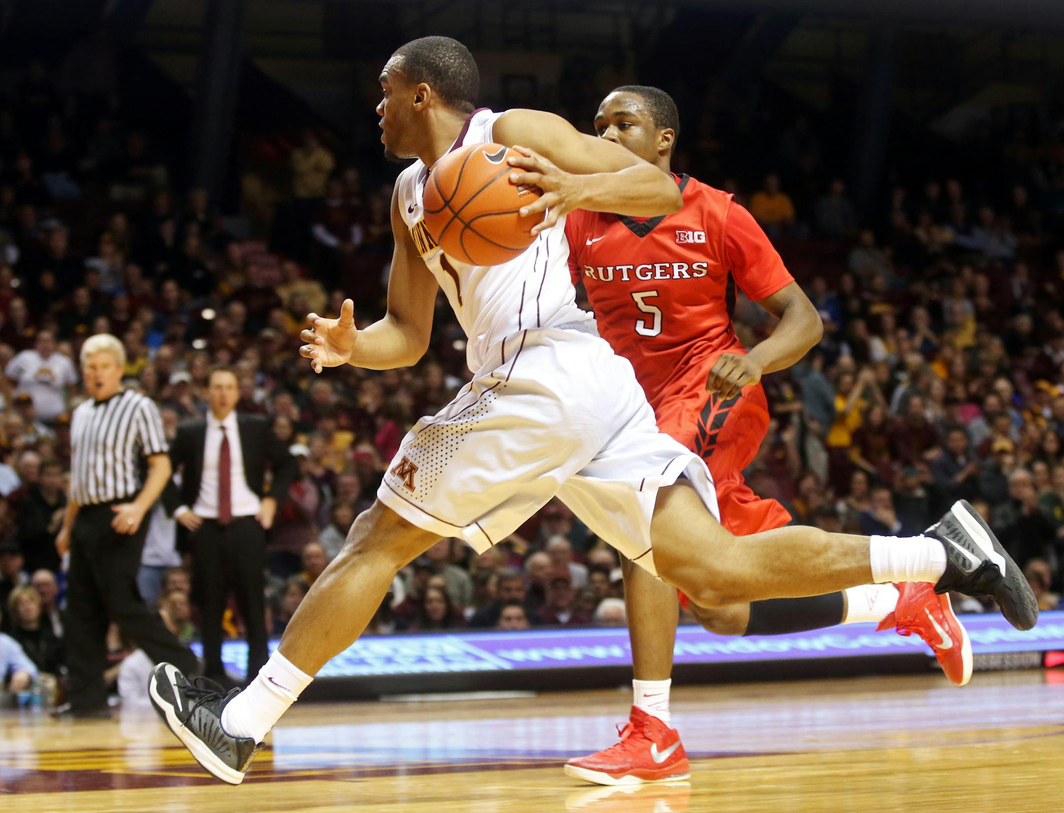 Minnesota&#x2019;s Andre Hollins, right, drives around Rutgers&#x2019;s Mike Williams in the second half of an NCAA college basketball game, Saturday, Jan. 17, 2015, in Minneapolis. Hollins led Minnesota with 31 points in their 89-80 win. (AP Photo/Jim Mone)