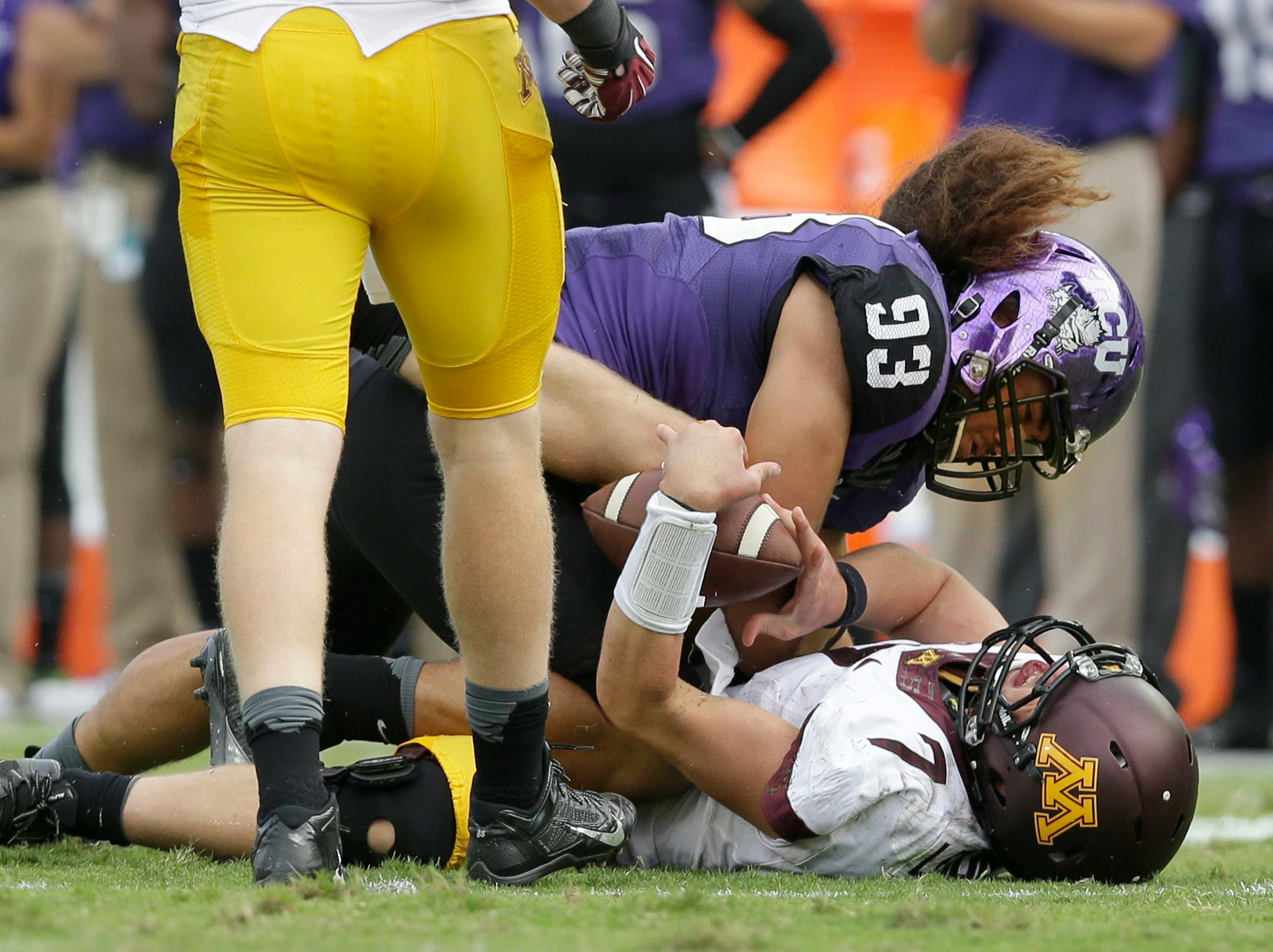 Minnesota quarterback Mitch Leidner (7) takes a hard hit from TCU defensive end Mike Tuaua (93) during the second half of an NCAA college football game, Saturday, Sept. 13, 2014, in Fort Worth, Texas. Leidner left the game after the play. TCU won 30-7.