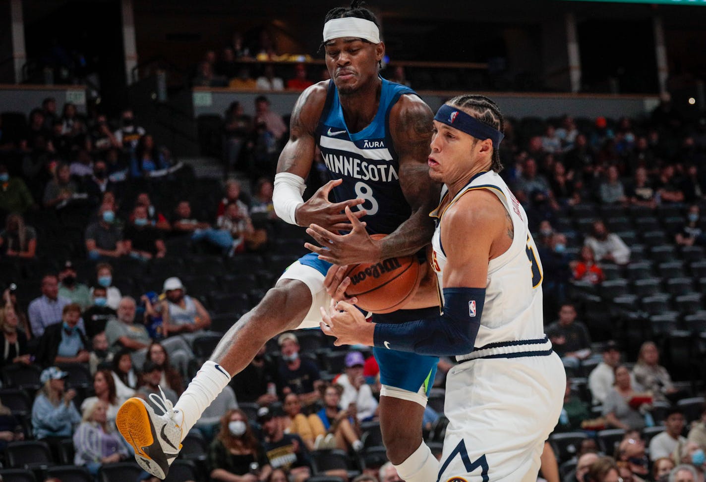 Minnesota Timberwolves forward Jarred Vanderbilt (8) drives to the basket against Denver Nuggets forward Aaron Gordon during the first half of a preseason basketball game in Denver, Friday, Oct. 8, 2021. (AP Photo/Joe Mahoney)