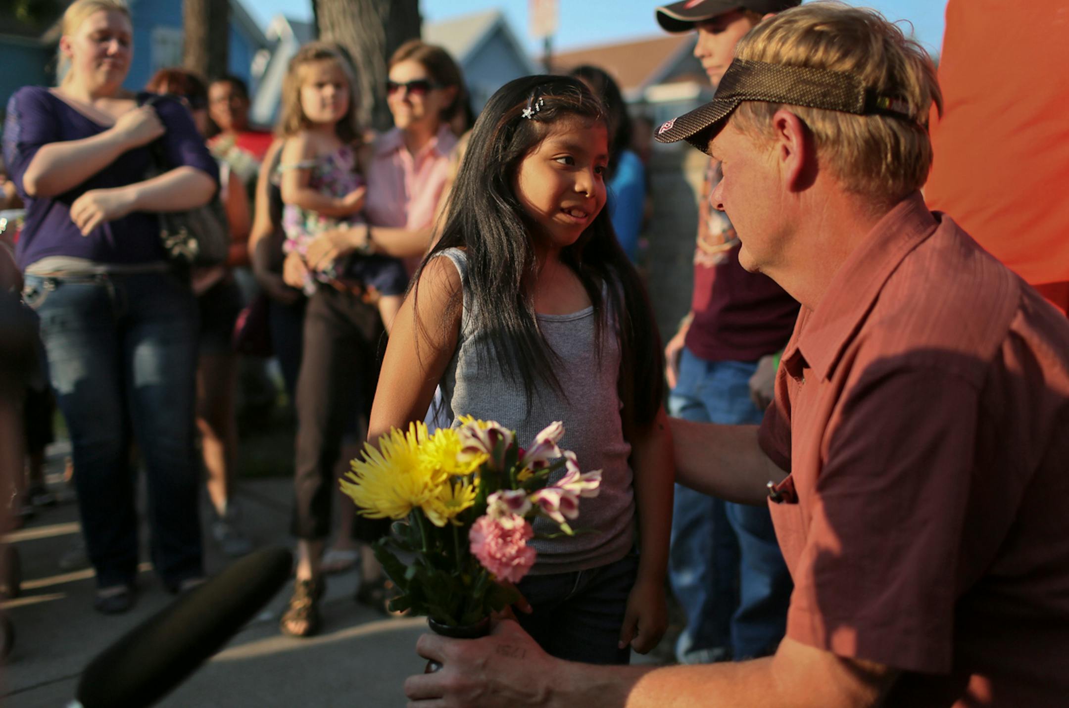 Jerome Hanson, Jessica Hanson's dad, received a vase with flowers from an unidentified girls as friends and other family members gathered at the corner of Pleasant and 28th St. in south Minneapolis during a vigil Friday.
