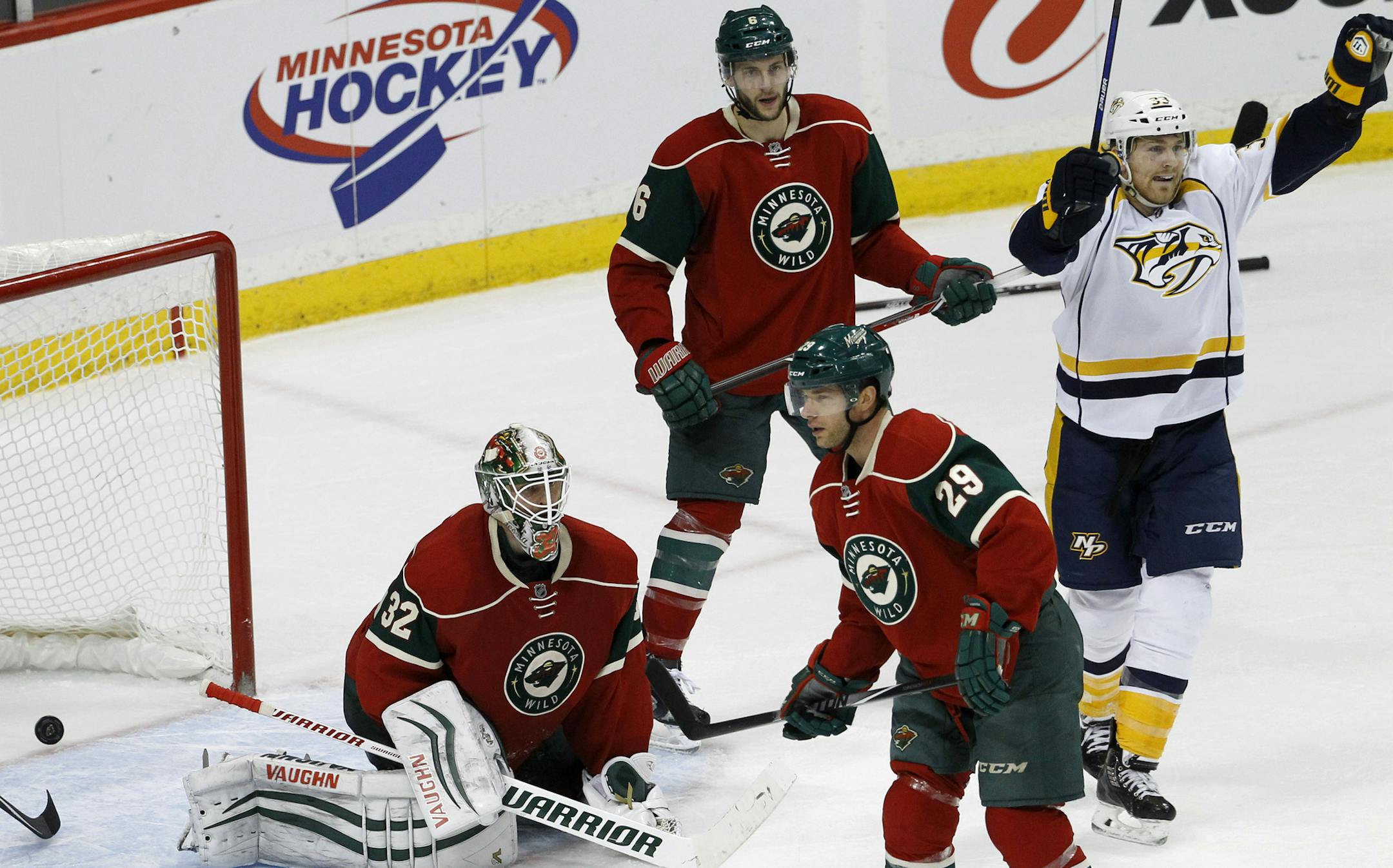 Nashville Predators center Colin Wilson, right, celebrates after a shot by Mattias Ekholm got past Minnesota Wild goalie Niklas Backstrom, left, of Finland, for the game-winning goal during overtime of an NHL hockey game in St. Paul, Minn., Saturday, Dec. 20, 2014. The Predators won 6-5. (AP Photo/Ann Heisenfelt)