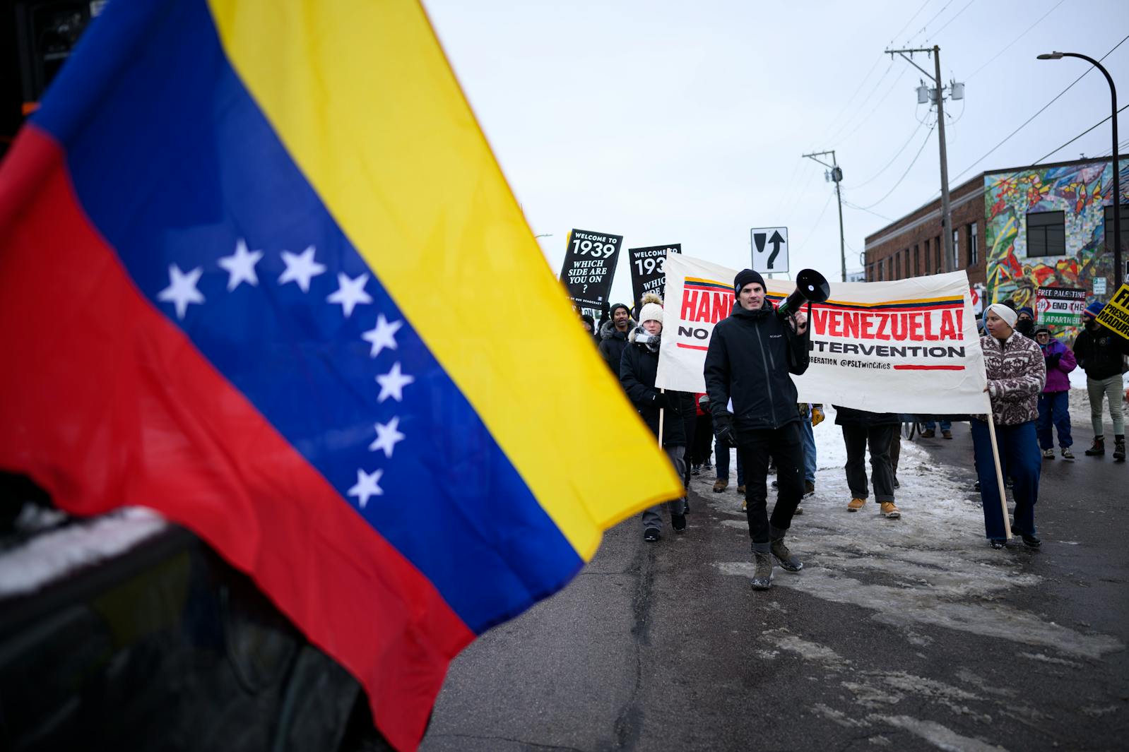 Simon Elliott, an organizer with the Party for Socialism and Liberation, chants on the megaphone while marching down Minnehaha Avenue in Minneapolis during a protest against U.S. military intervention in Venezuela on Jan. 3. A few hundred people joined together in a march organized by the Minnesota Peace Action Coalition on the day President Donald Trump announced the capture of Venezuelan President Nicolás Maduro.