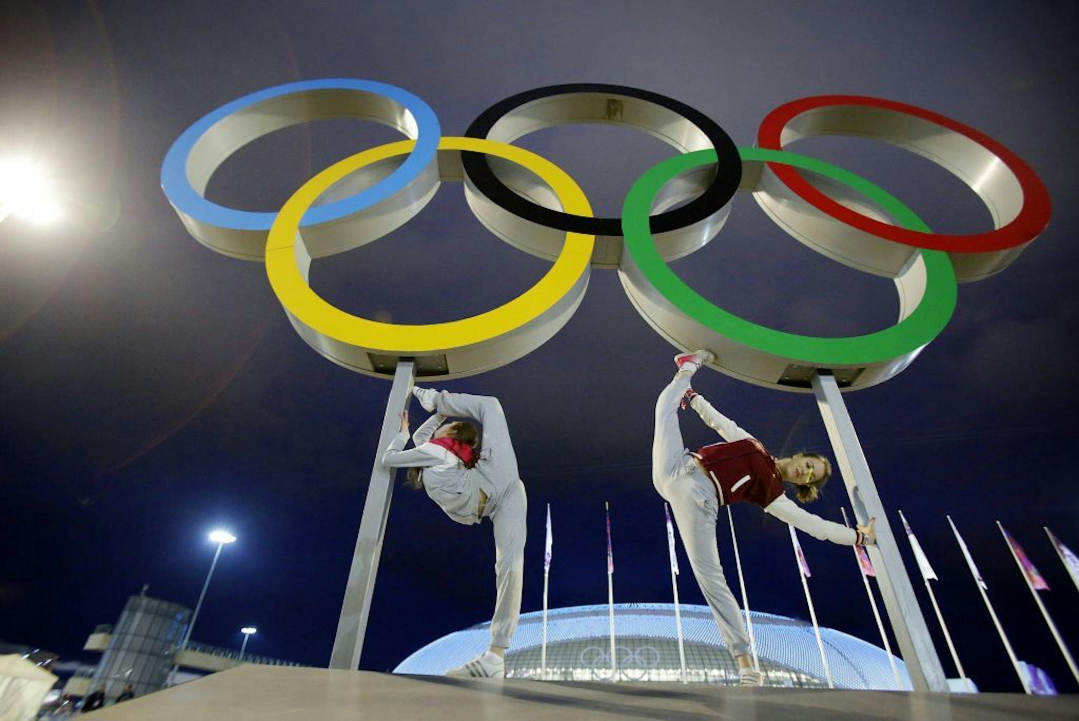 Russian dancers who will be performing at the opening ceremony pose with the Olympic rings as their friend photographs them, ahead of the 2014 Winter Olympics, Thursday, Feb. 6, 2014, in Sochi, Russia.