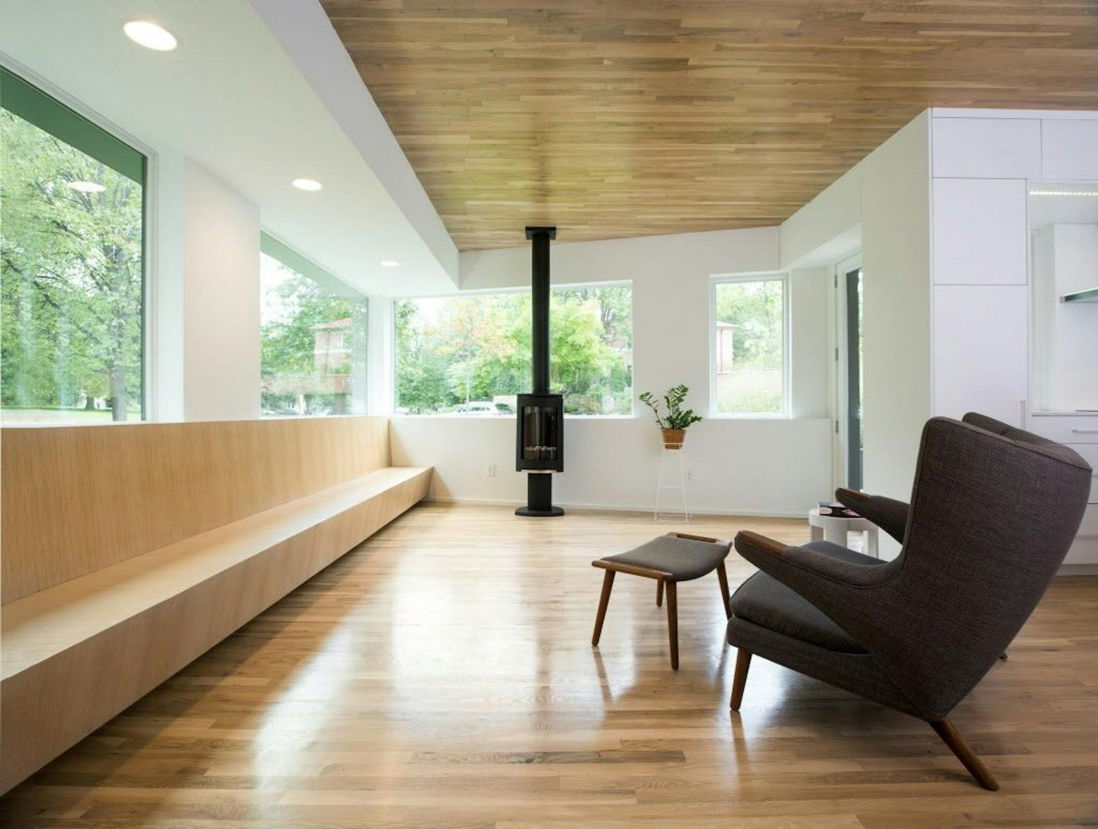 The living room features a built-in bench and wood-burning stove.