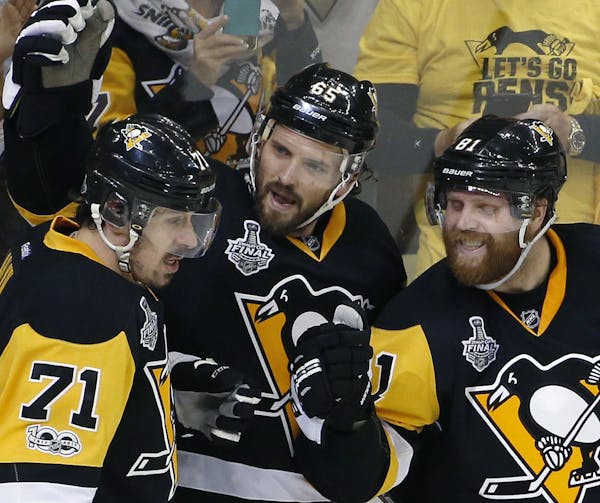 Pittsburgh Penguins' Ron Hainsey, center, celebrates his goal against the Nashville Predators with Evgeni Malkin, left, and Phil Kessel, right, during