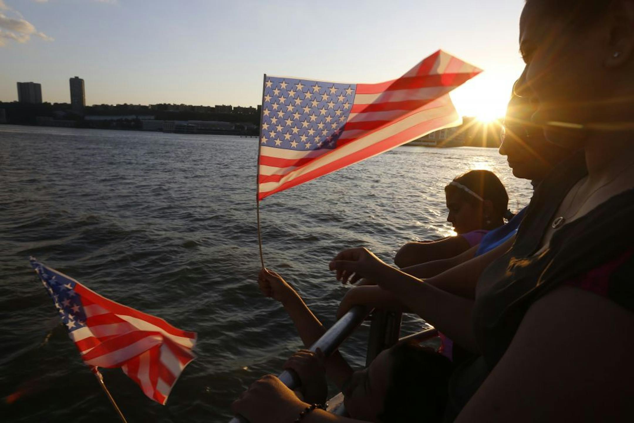 A patron waves an American flag during a Fourth of July cruise on the Hudson River in New York, July 4, 2013.