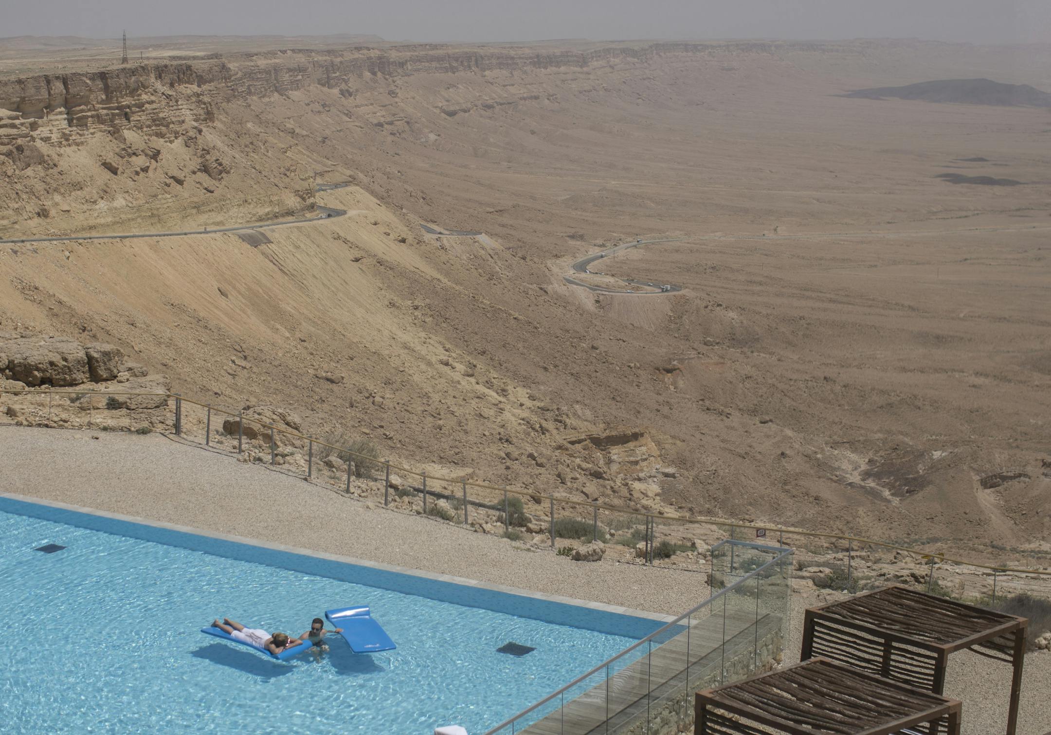 Tourists, swimming in a pool overlooking the Ramon Crater at hotel Beresheet, in Mitzpe Ramon in the Negev desert in Israel, April 30, 2015. With its part-Mediterranean, part-desert climate, Israel had suffered from water shortages for decades, but a national effort to desalinate Mediterranean seawater and to recycle wastewater has provided Israel with enough water for all its needs. (Uriel Sinai/The New York Times)