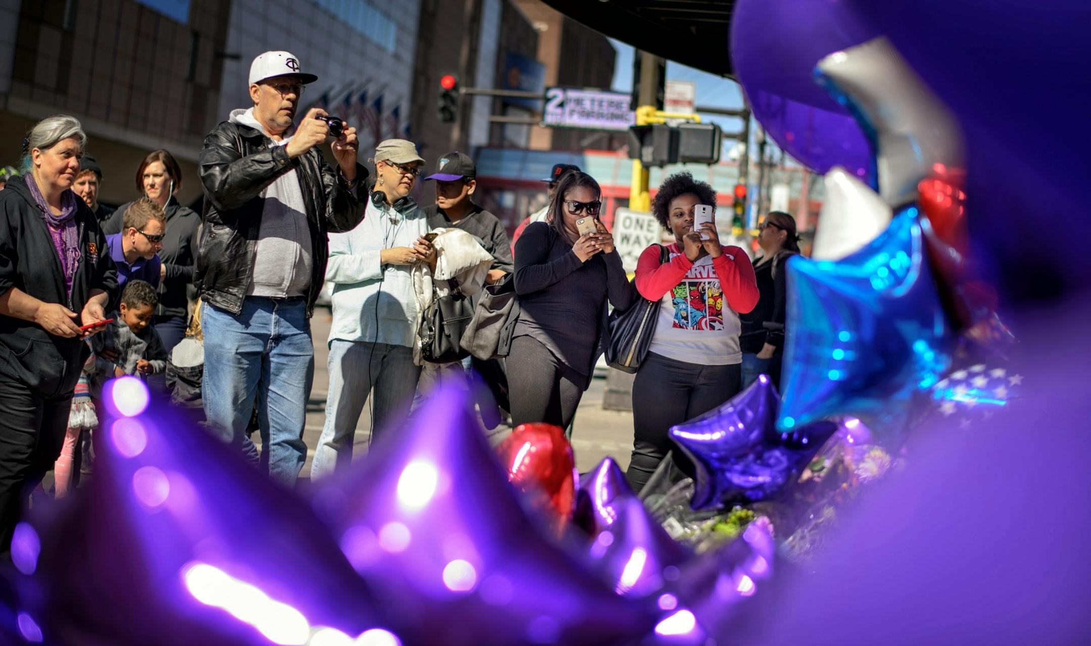 People filed past the makeshift memorial next to Prince's star on First Avenue's wall of stars. They took photos and posed for their own, left letters, purple flowers and balloons. Music by Prince blared from the speakers of passing cars.