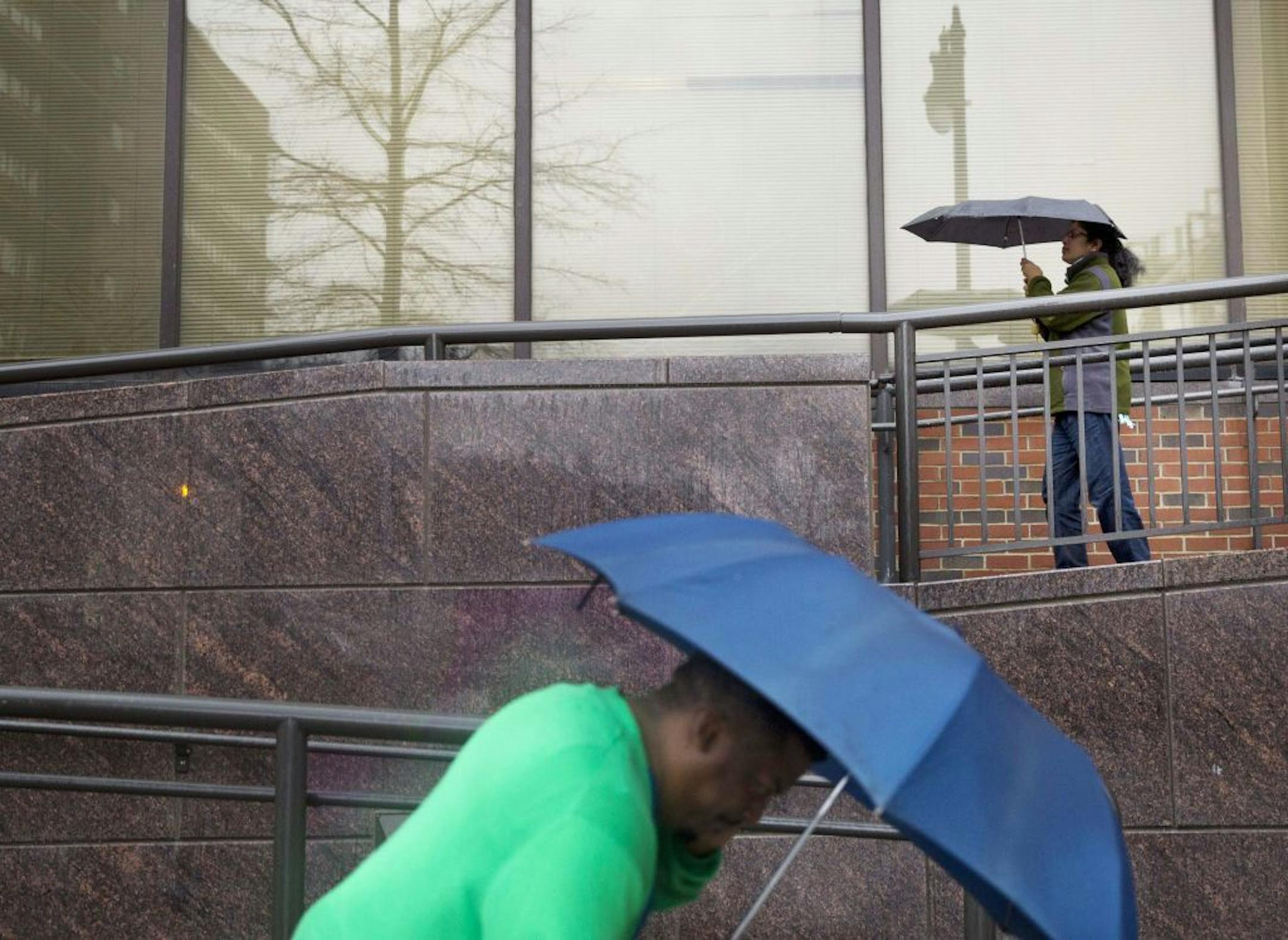 Pedestrians walk to brave the rain and high winds, Wednesday, Dec. 23, 2015, in Birmingham, Ala. A weather pattern that could be associated with El Nino has turned winter upside-down across the U.S. during a week of heavy holiday travel, bringing spring-like warmth to the Northeast, a risk of tornadoes in the South and so much snow in parts of the West that there are concerns about avalanches. On Christmas Day, it could be warmer in New York City than Los Angeles.