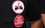 Tesla worker Mikey Catura, wears a t-shirt and button to support the workers at the Tesla factory in Fremont, California, on Friday, Aug. 11, 2017. Ca