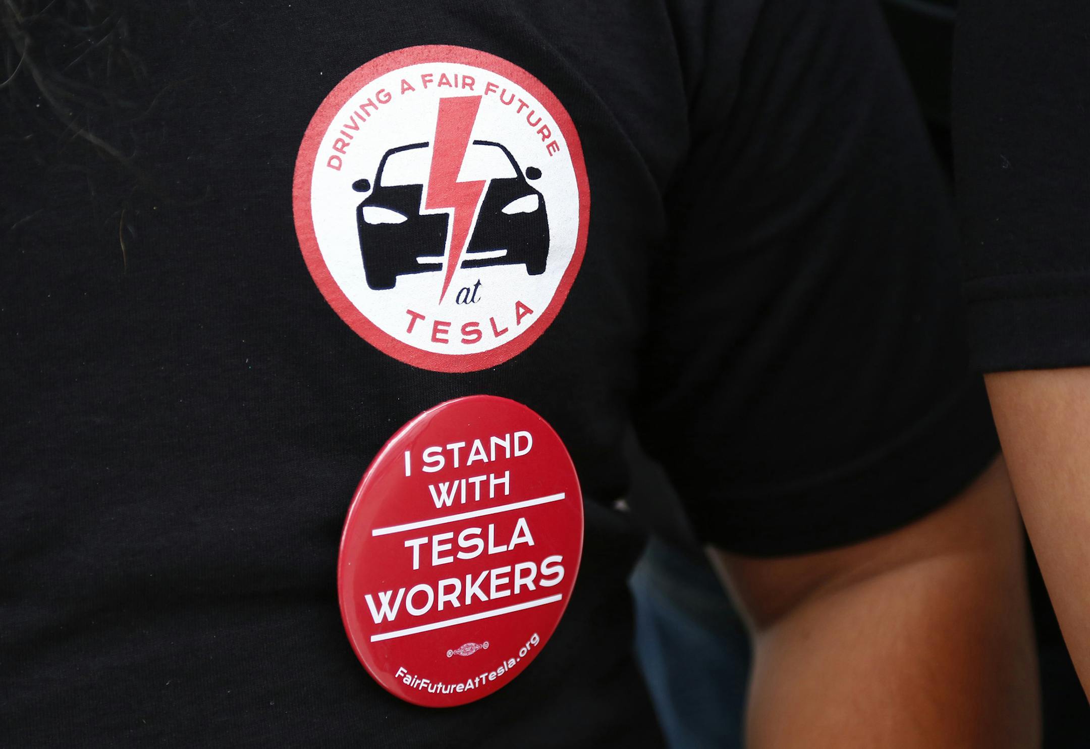 Tesla worker Mikey Catura, wears a t-shirt and button to support the workers at the Tesla factory in Fremont, California, on Friday, Aug. 11, 2017. Catura has joined fellow workers in voicing their concerns on workplace safety and wages as Tesla ramps up production to deliver its new Model 3 later this year. (Gary Reyes/ Bay Area News Group/TNS) ORG XMIT: 1208750