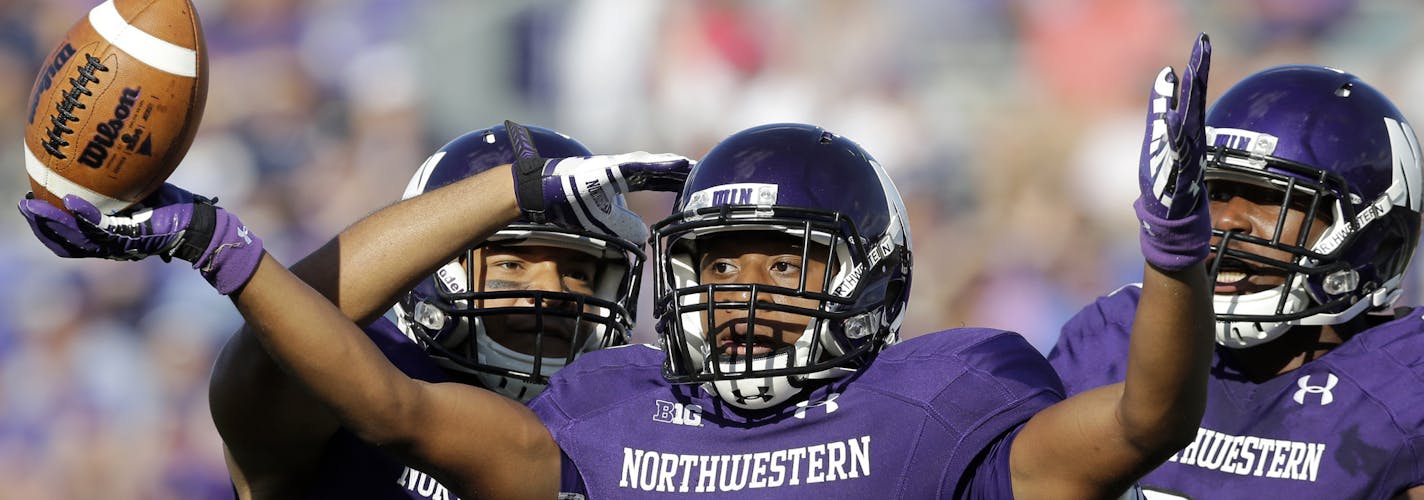 Northwestern running back Justin Jackson (28), center, celebrates with wide receiver Tony Jones (6), left, and wide receiver Tom Fuessel (81) after scoring a touchdown during the second half of an NCAA college football game against California in Evanston, Ill., Saturday, Aug. 30, 2014. California won 31-24. (AP Photo/Nam Y. Huh) ORG XMIT: ILNH117