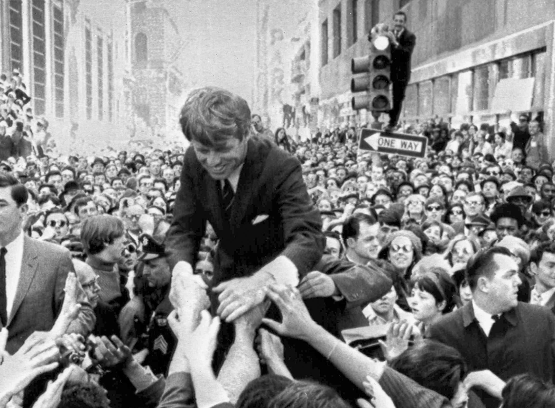 FILE - In this April 2, 1968 file photo U.S. Sen. Robert F. Kennedy, D-NY, shakes hands with people in a crowd while campaigning for the Democratic party's presidential nomination on a street corner, in Philadelphia. Nearly 50 years after Robert F. Kennedy's assassination, a new documentary series on his life and transformation into a liberal hero is coming to Netflix. "Bobby Kennedy for President" produced by RadicalMedia, Trilogy Films and LooksFilm launches Friday, April 27, 2018, on Netflix.
