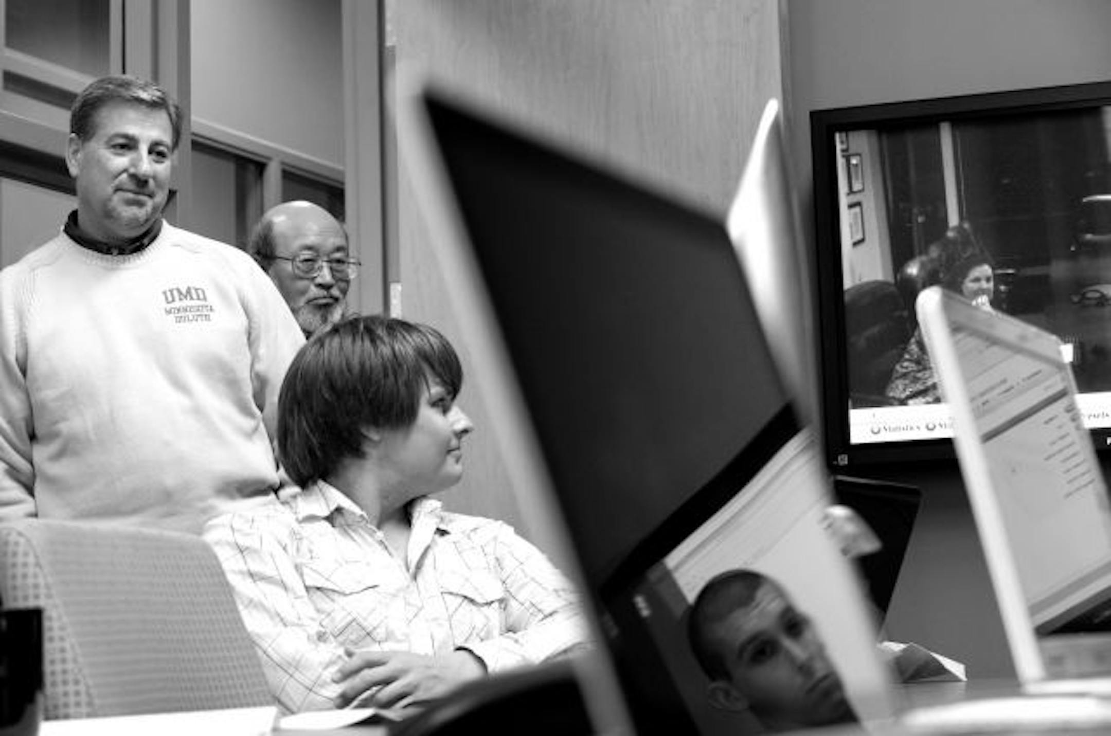 Richard Brown, left, of JNBA Financial Advisors and Dr. Shee Q. Wong of UMD collaborated on one of the first financial planning learning labs in the country. Students Ron Moen and Sean Finn received advice form Marie Williams via video conferencing from JNBA's Bloomington office.
