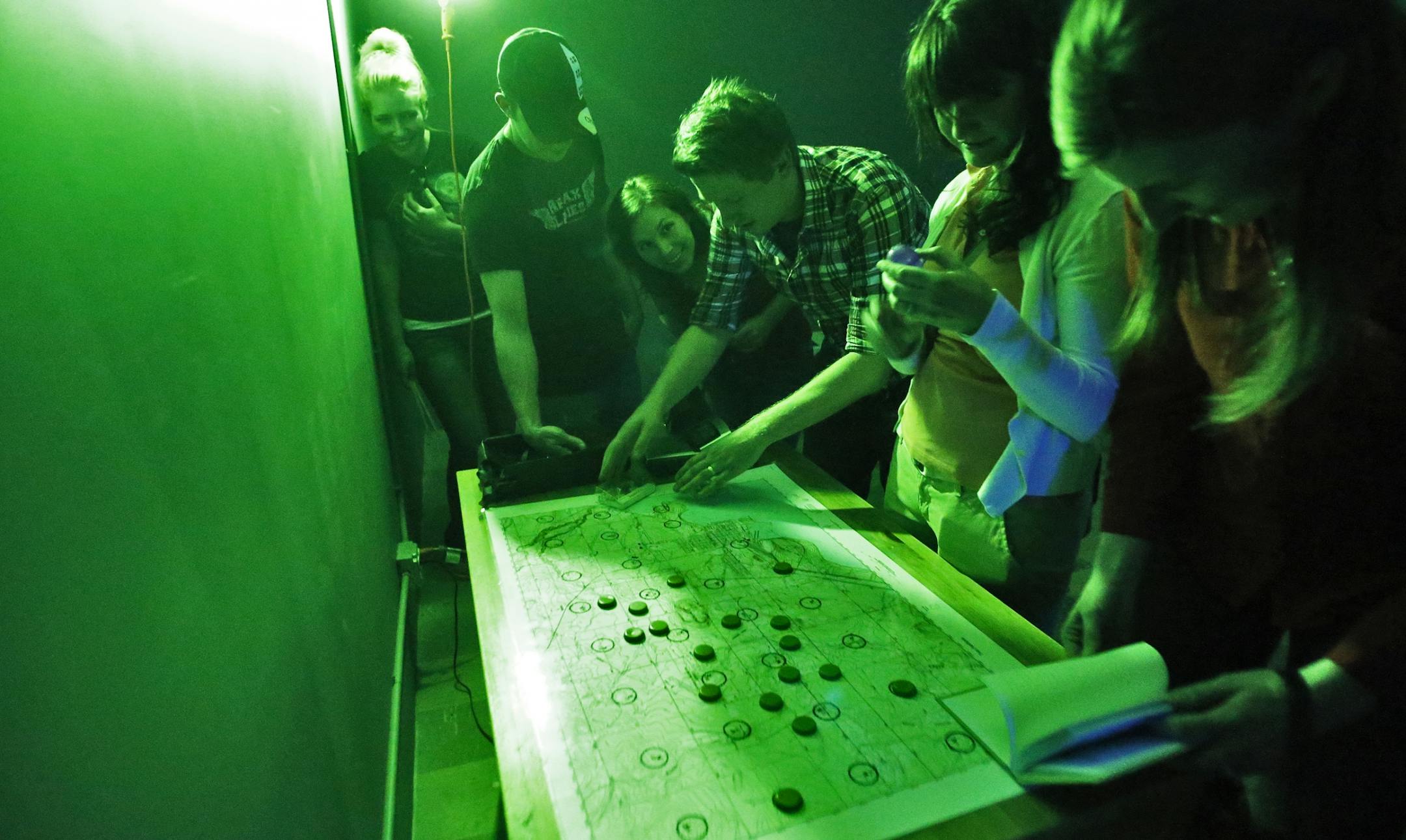 A group works on the various clues presented to them in an effort to find passage out of the riddle room.