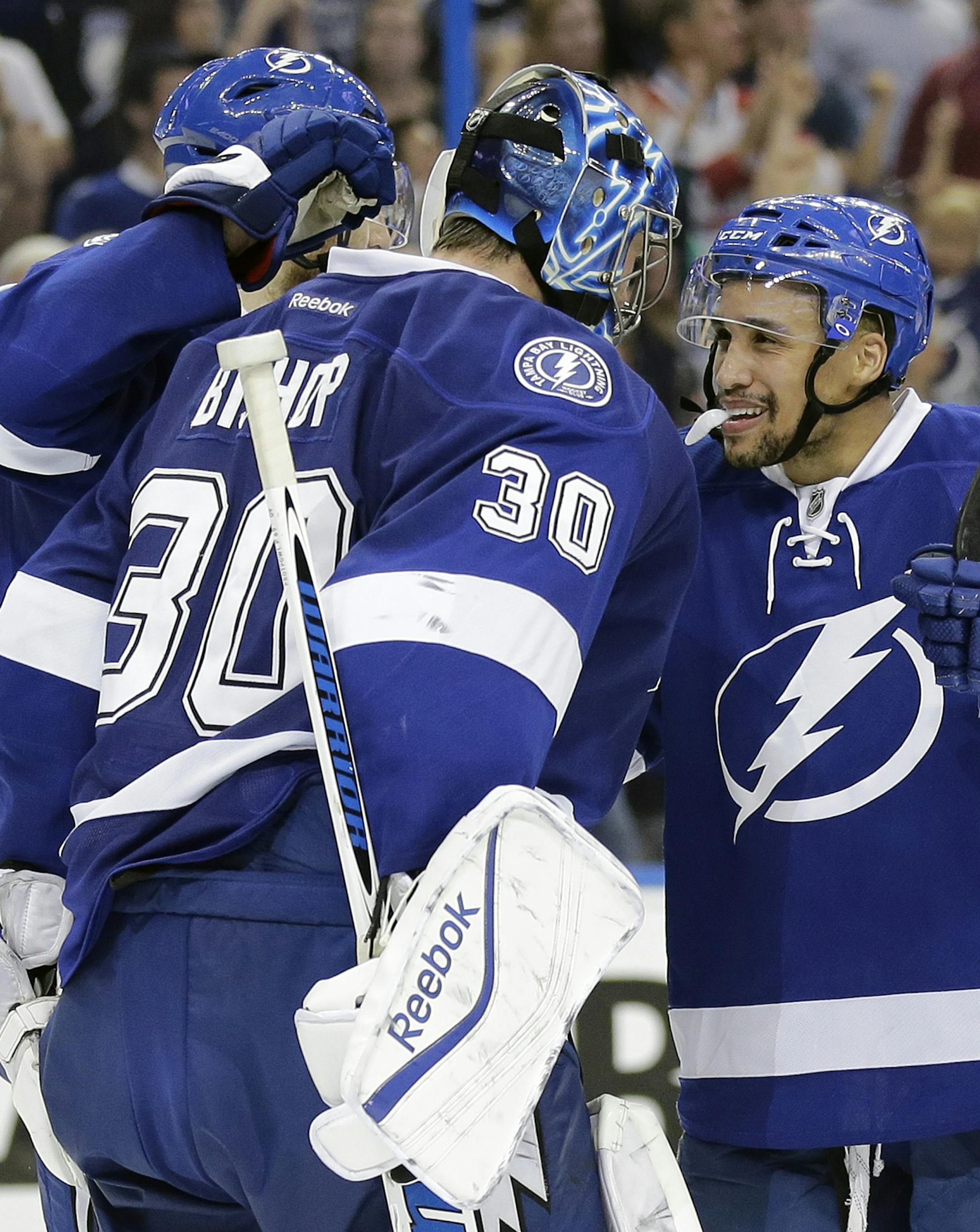 Tampa Bay Lightning goalie Ben Bishop (30) celebrates with right wing J.T. Brown (23) after the team defeated the Montreal Canadiens 4-1 during Game 6 of a second-round NHL Stanley Cup hockey playoff series Tuesday, May 12, 2015, in Tampa, Fla. (AP Photo/Chris O'Meara)