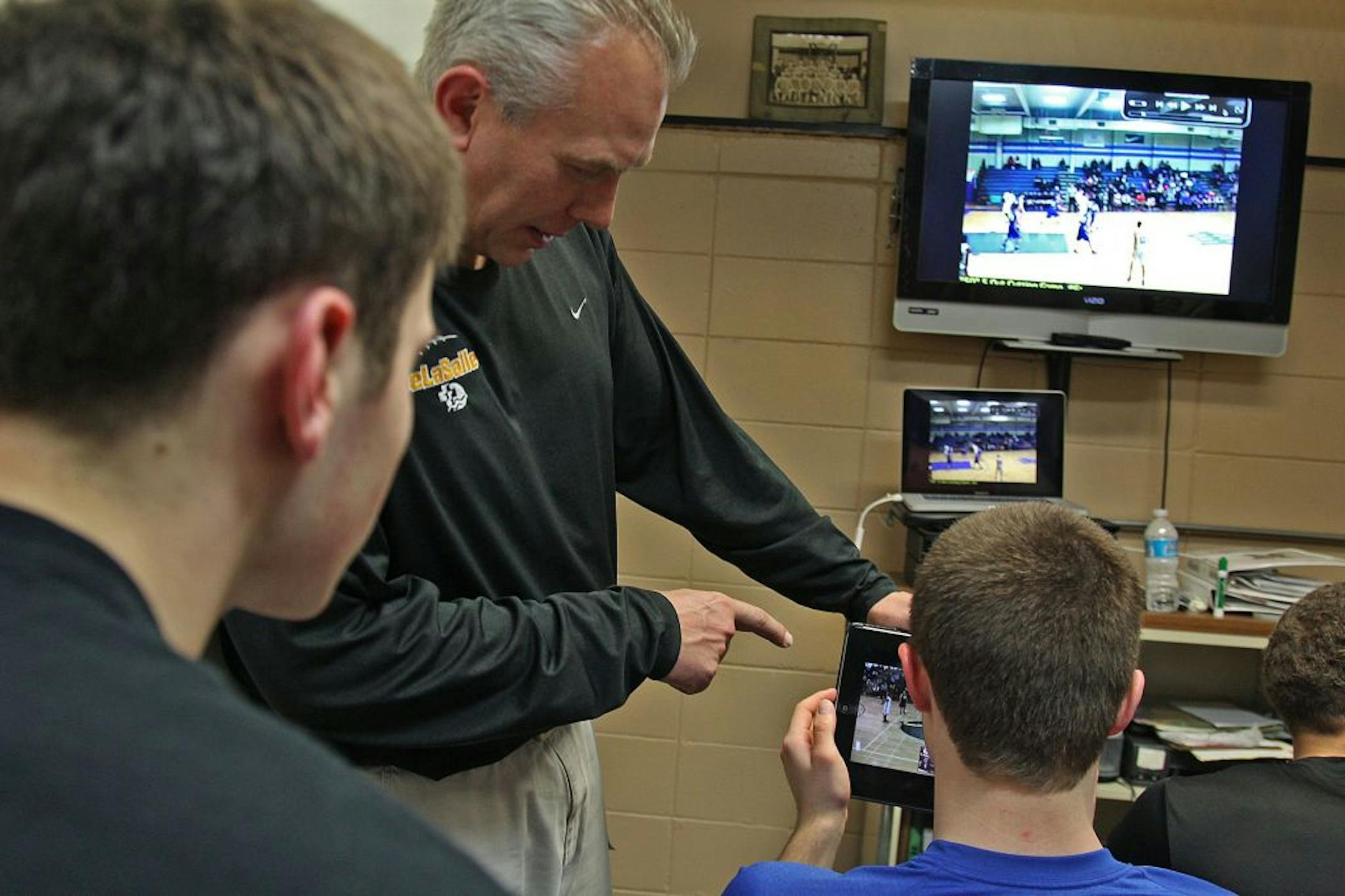 DeLaSalle boys' basketball coach Dave Thorson helped his players analyze game footage of past and future opponents using iPads and laptops after a recent practice. Computer software and the Internet enable coaches such as Thorson to quickly break down and disperse film for players to access on mobile devices.