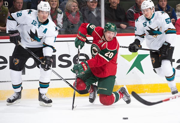 Minnesota Wild defenseman Ryan Suter (20) goes down to the ice for the puck while being challenged by San Jose Sharks center Patrick Marleau (12) and 