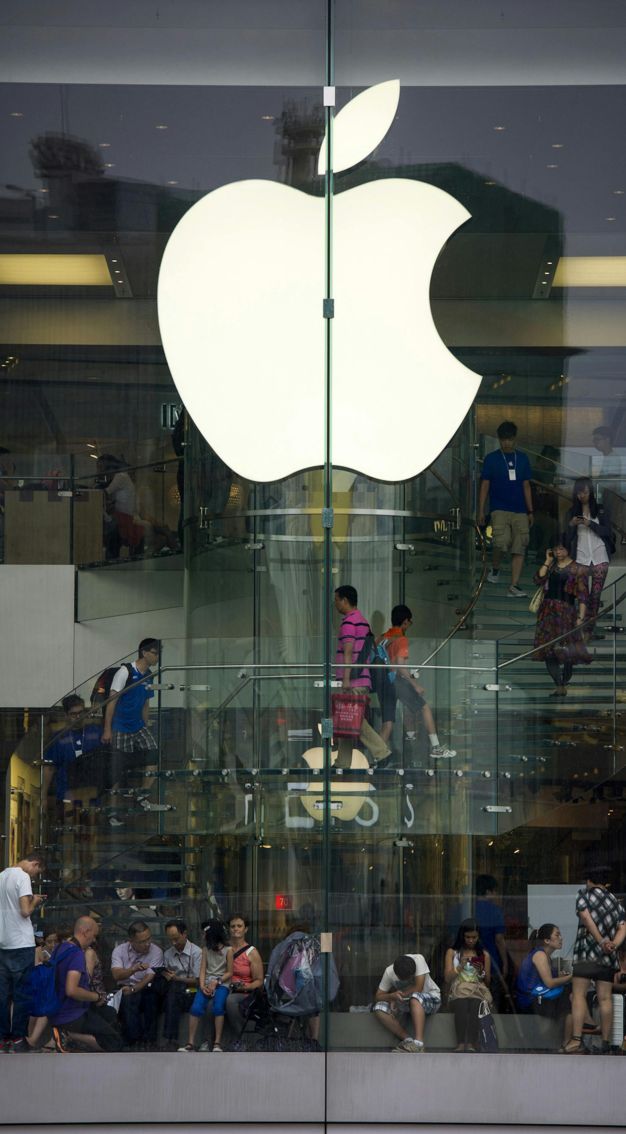 Customers shop at an Apple Inc. store in Hong Kong, China, on Tuesday, July 16, 2013, on Tuesday, July 16, 2013. Apple Inc., is expected to release earnings figures on July 23. Photographer: David Paul Morris/Bloomberg ORG XMIT: 174409724