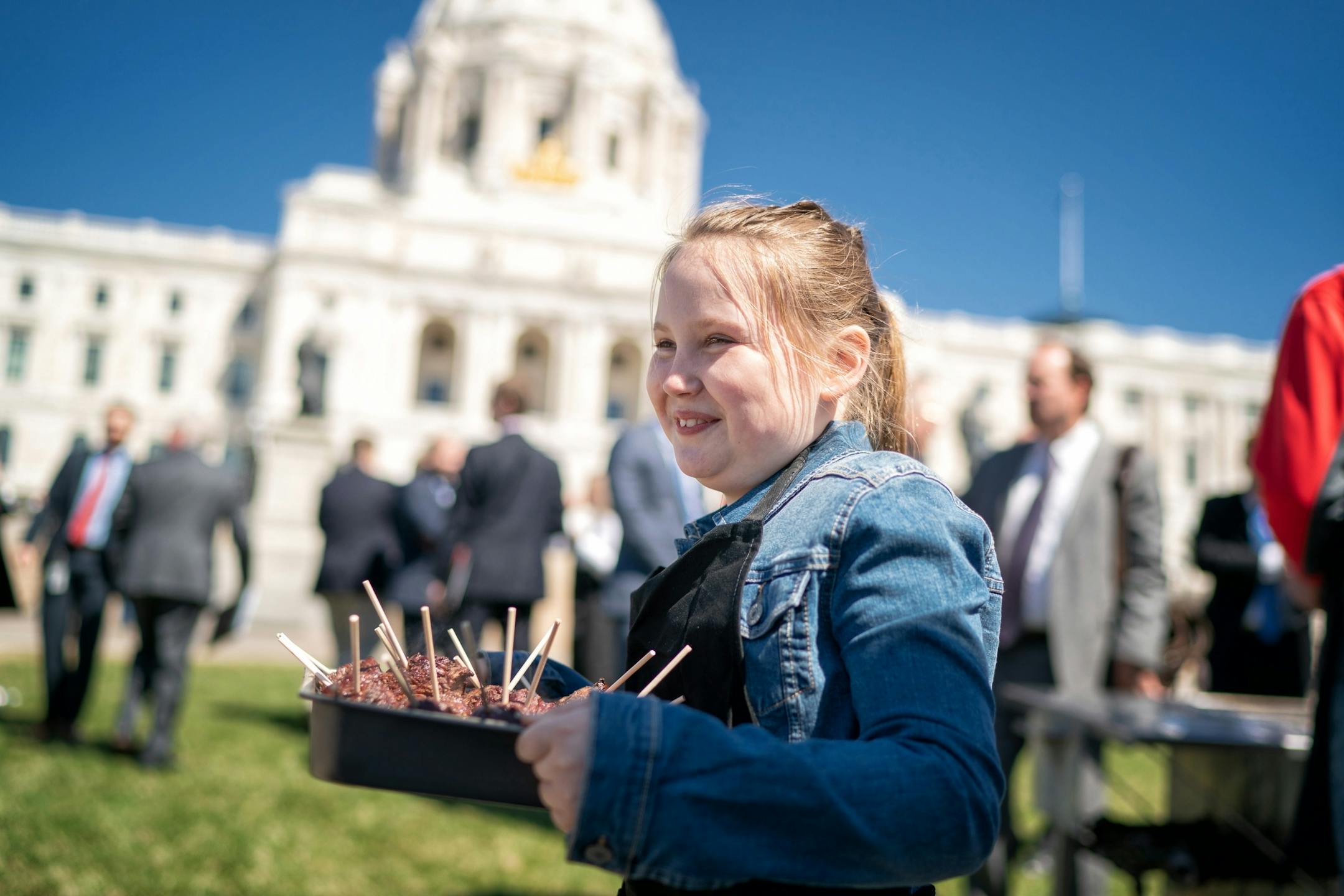 Avery Kohls, 10, smiled as she delivered a tray of 4-oz beef tenderloins, fresh from the grill at the annual Minnesota State Cattlemen's Association Steak on a Stick event. They grilled and distributed 550. Avery's mom Ashley is the executive director of the Minnesota State Cattlemen's Association.
