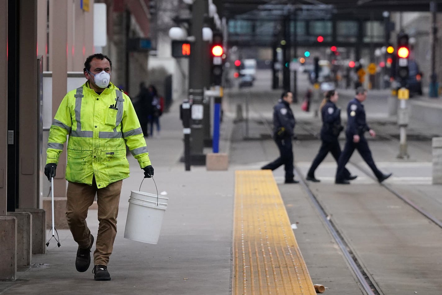 A worker wore a protective mask and gloves as he cleaned the light rail platform outside Union Depot in St. Paul last weekend.